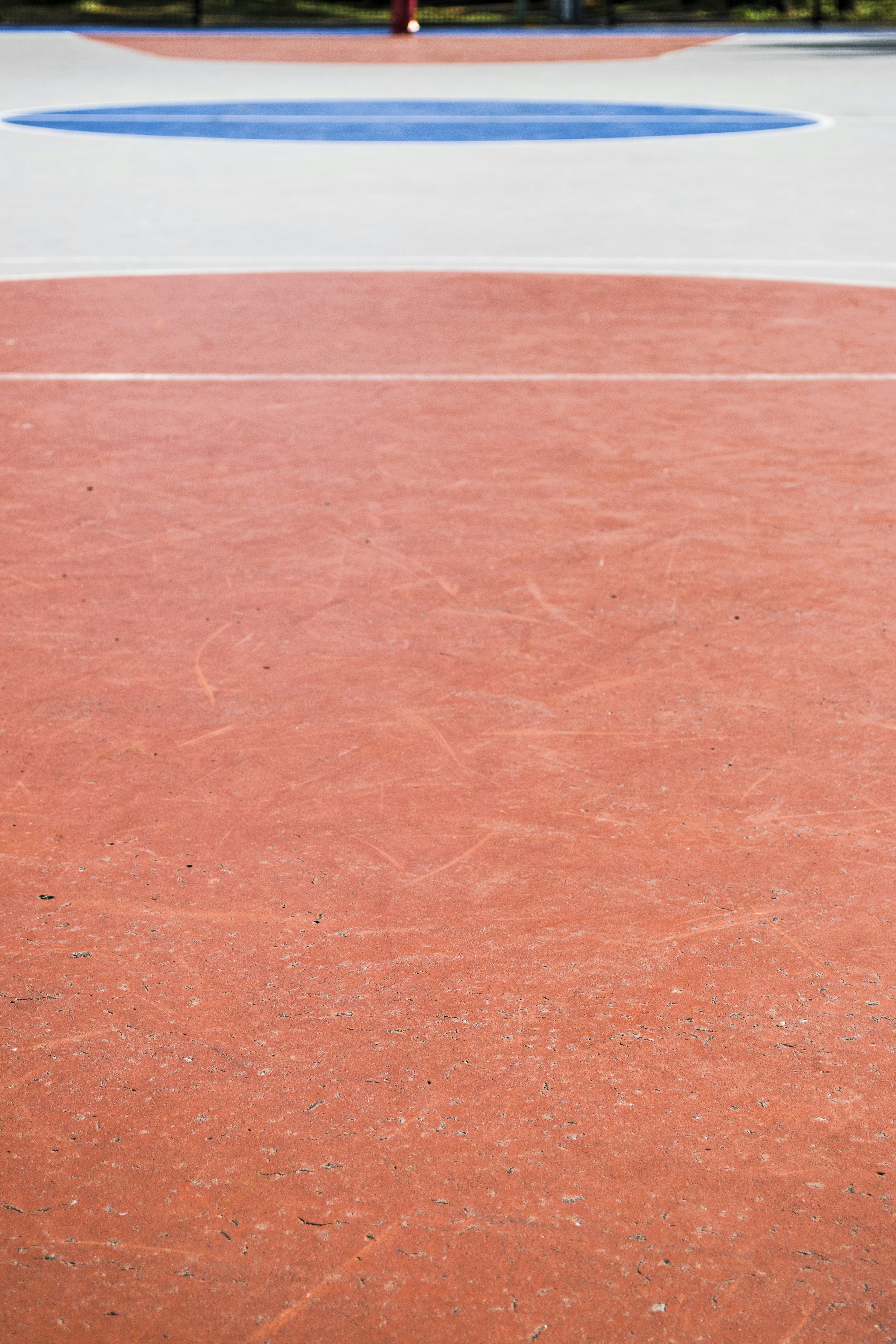 Gambar yang menunjukkan bagian dari lapangan basket dengan warna merah dan biru