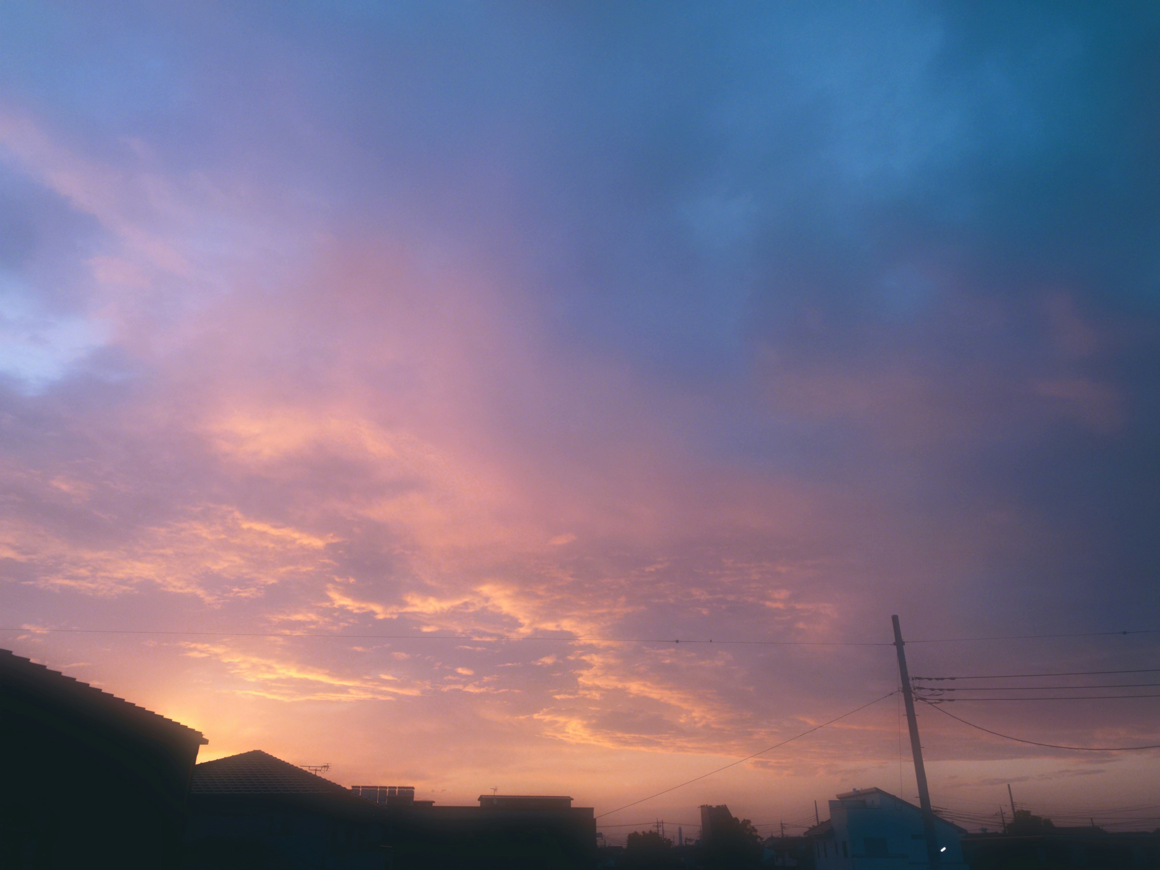 Colorful sunset sky with silhouetted houses