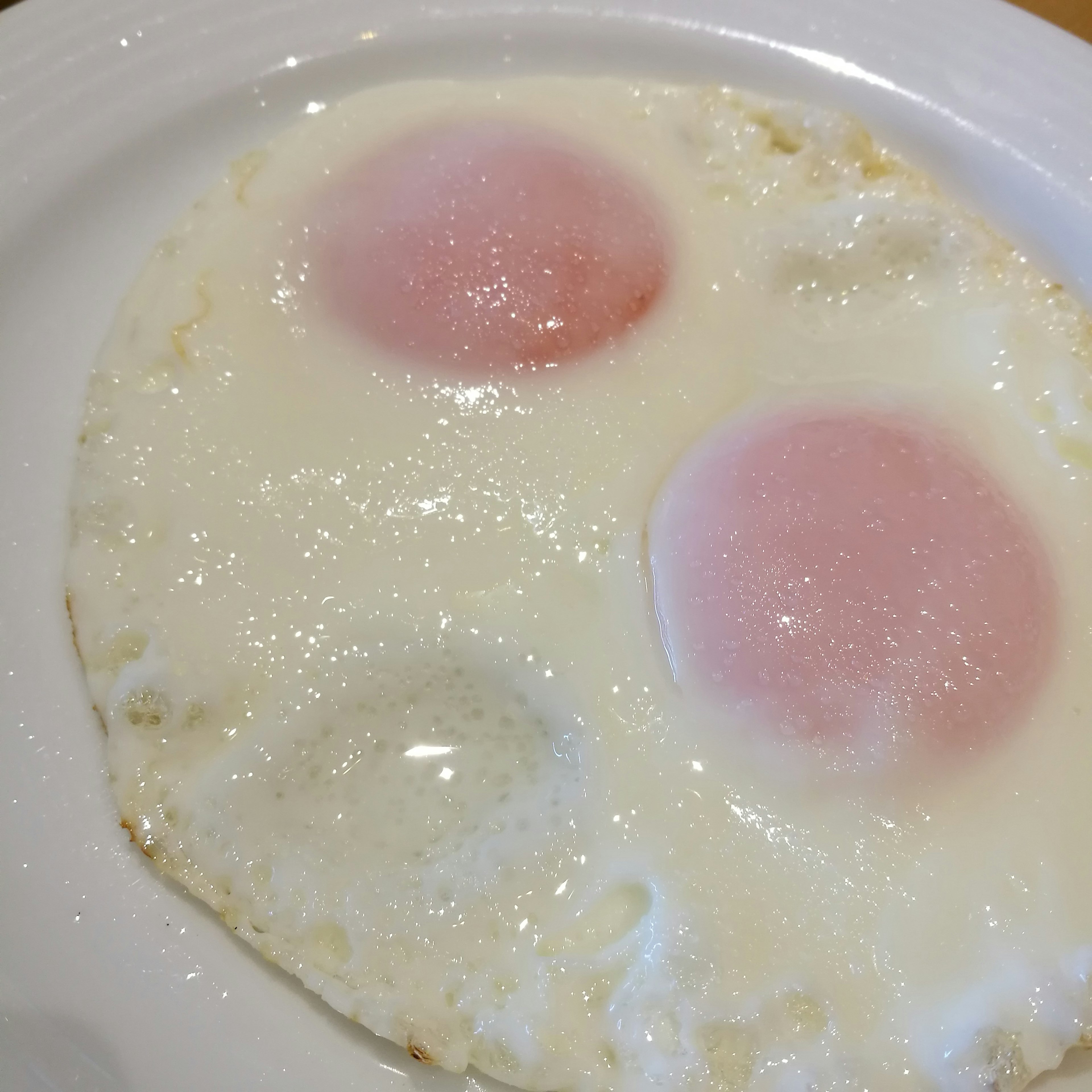 Dos huevos escalfados en un plato blanco