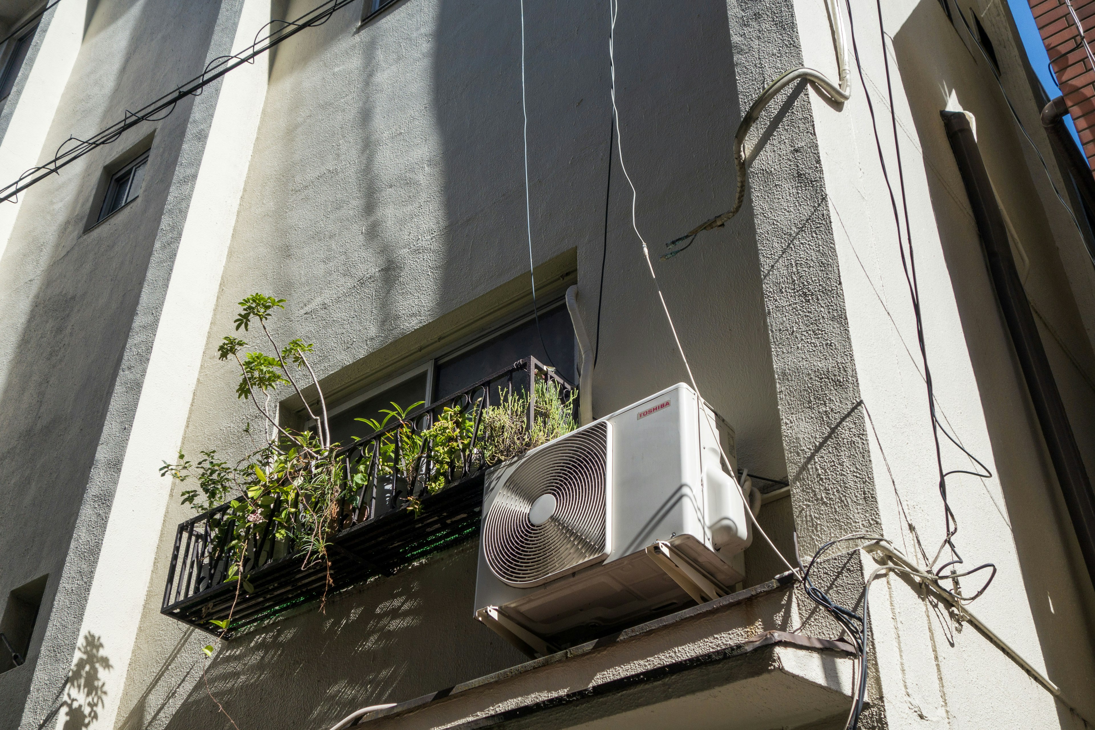 安装在建筑墙上的空调单元和花盆