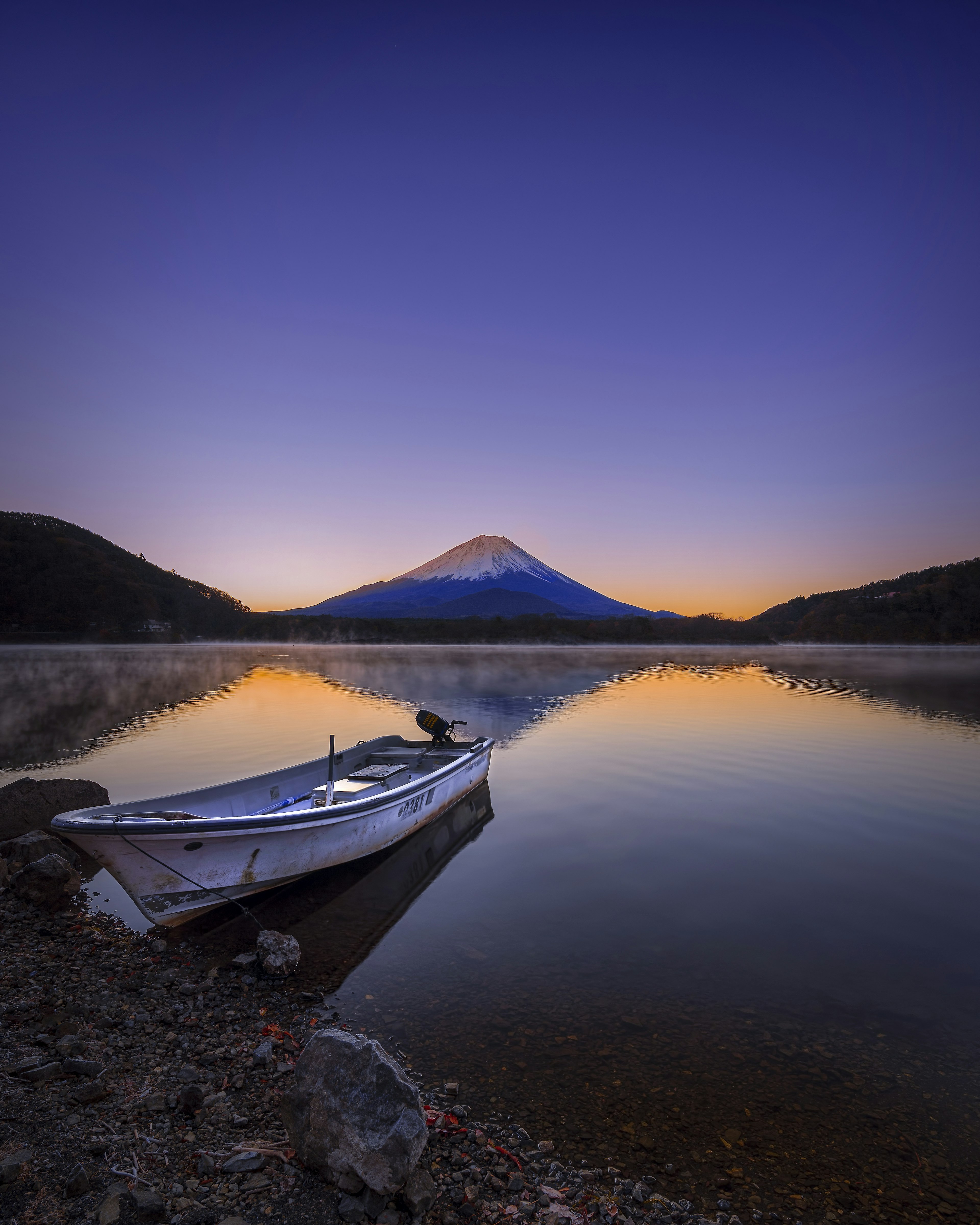 Vista mozzafiato del monte Fuji che si riflette in un lago calmo all'alba