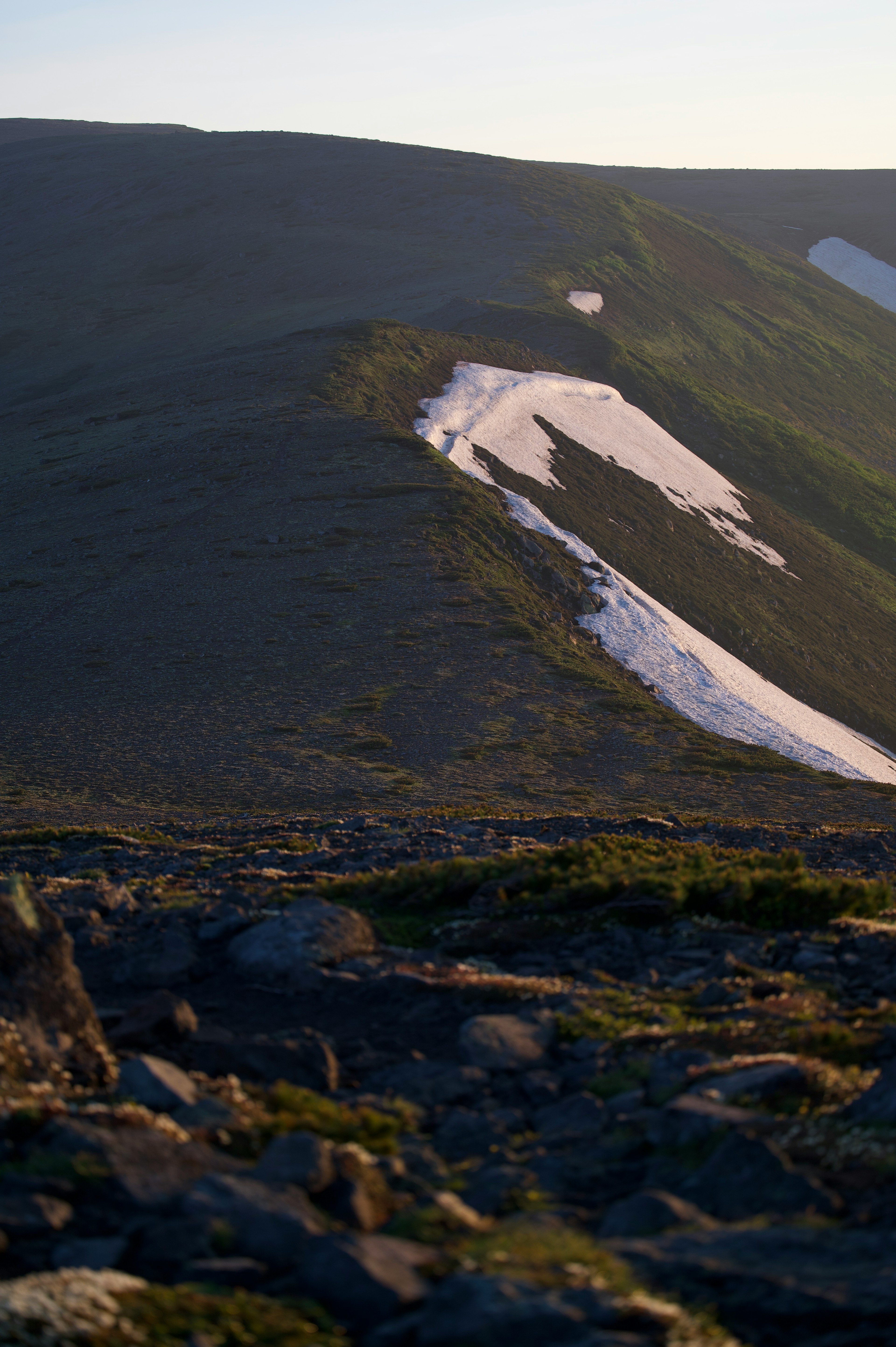 A mountain slope with remaining snow and visible rocks