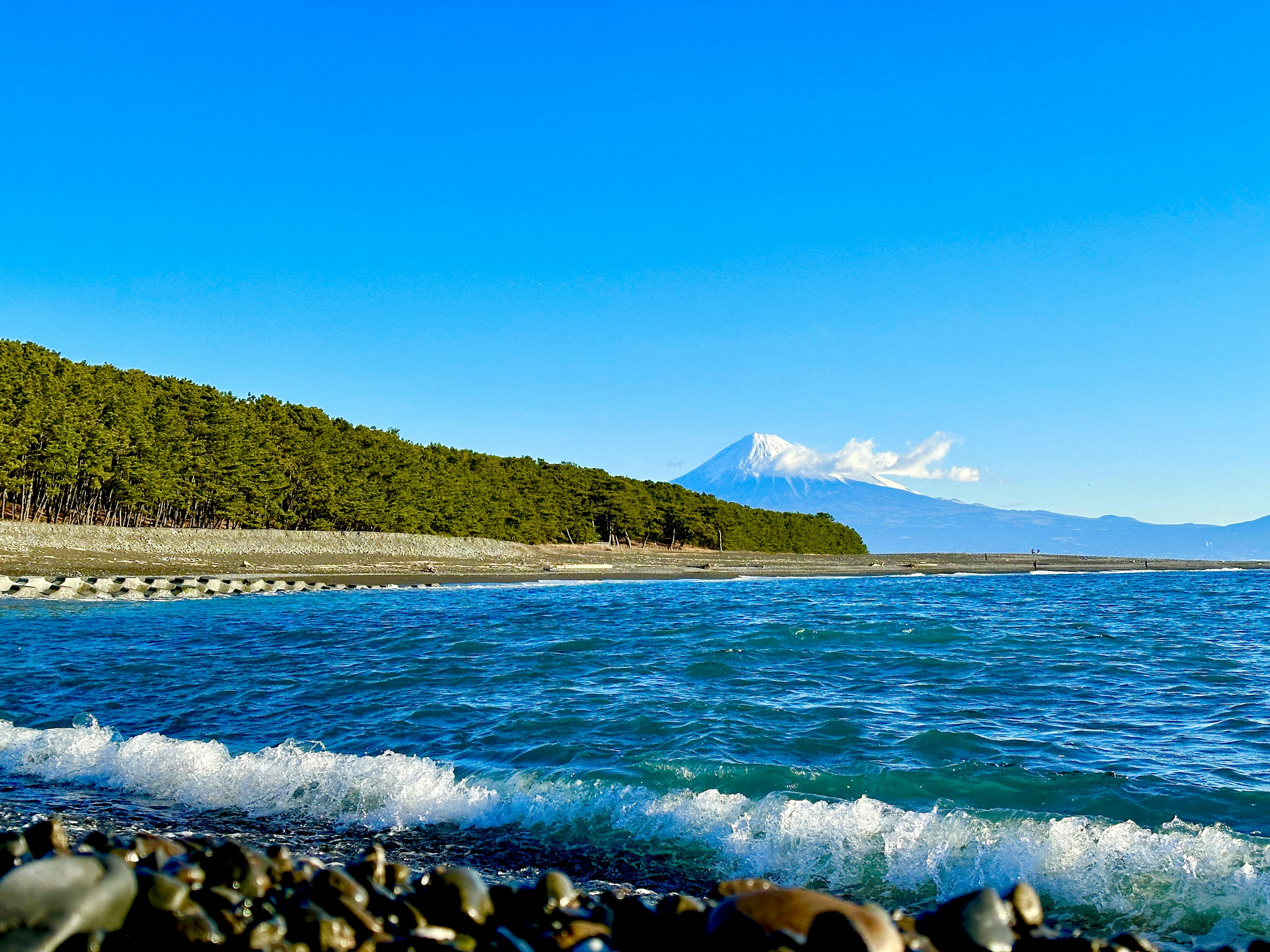 Malersicher Blick auf einen blauen Himmel und ruhiges Meer mit dem Fuji in der Ferne