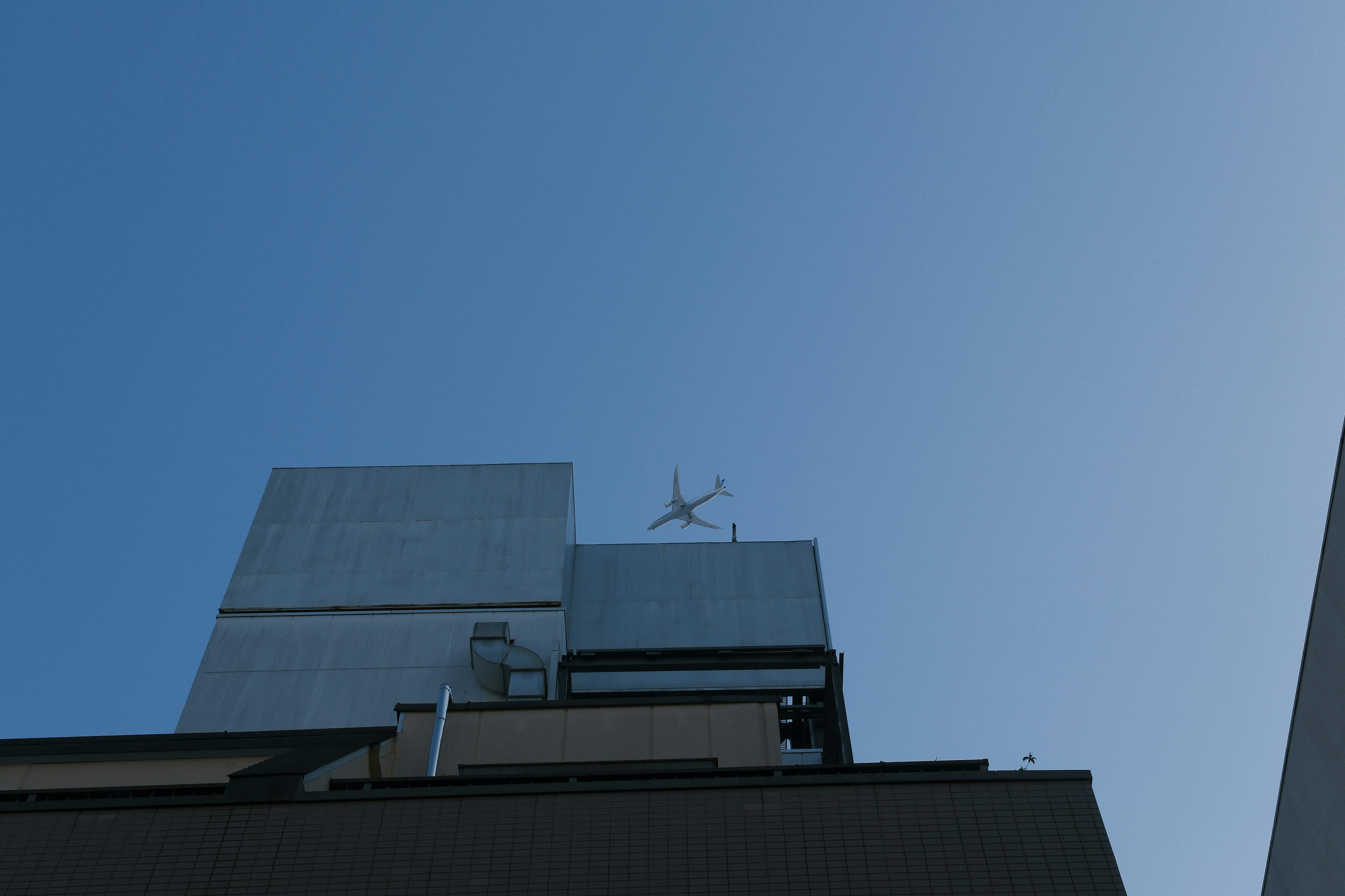 Building rooftop with antenna under blue sky