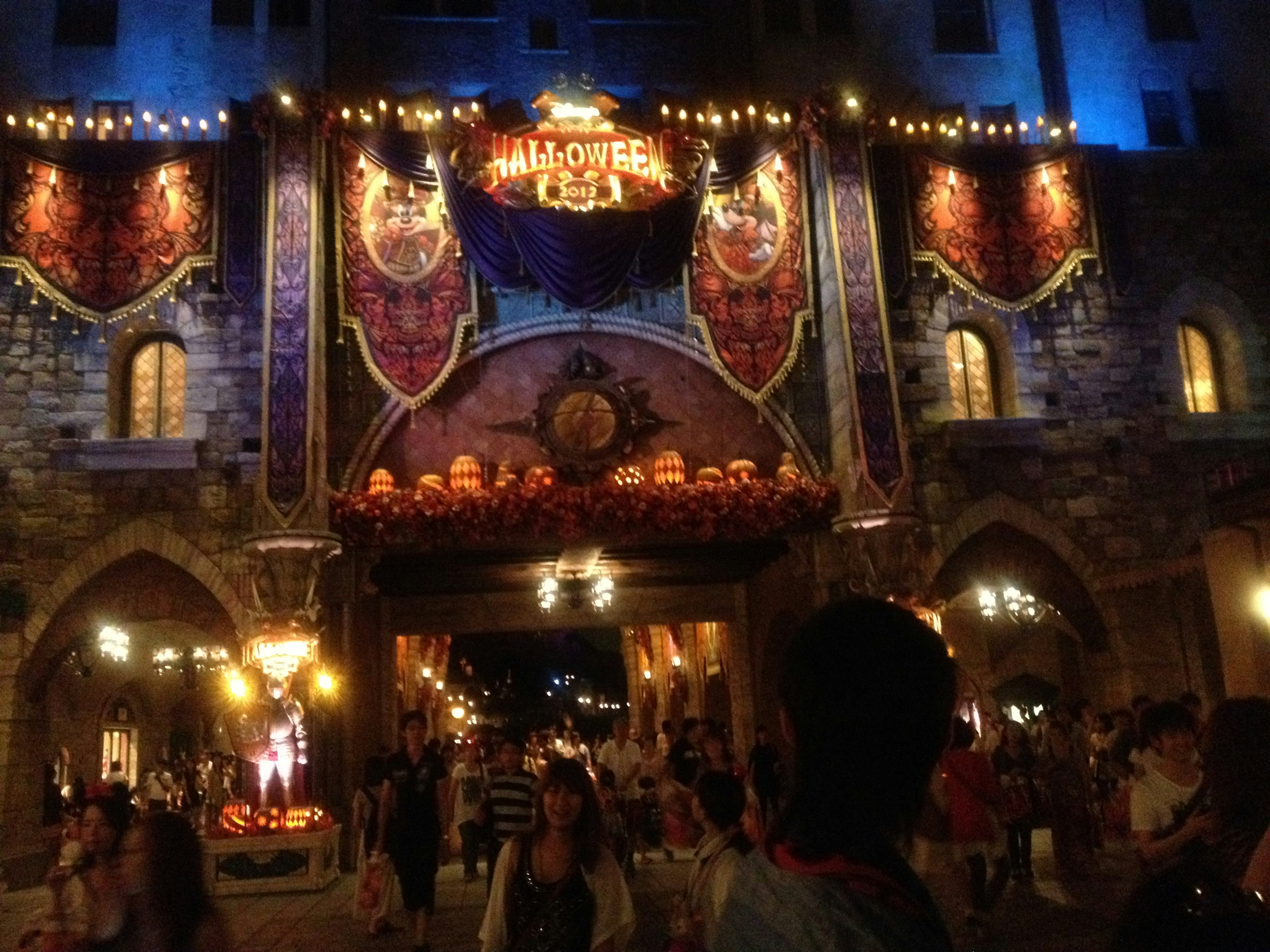 Entrance of a theme park decorated for Halloween with lights and banners