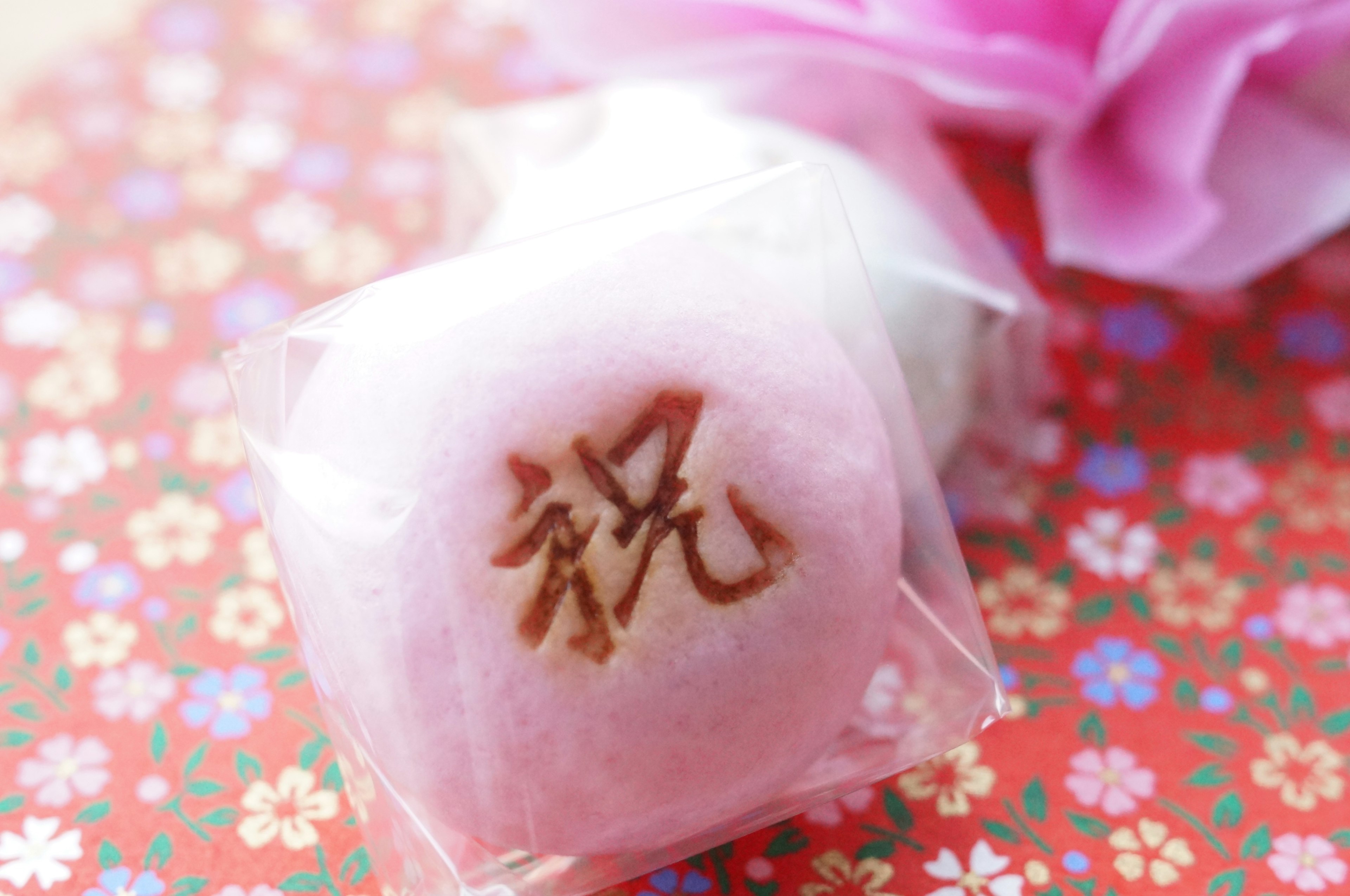 Pink Japanese confection wrapped in clear packaging with the character for celebration