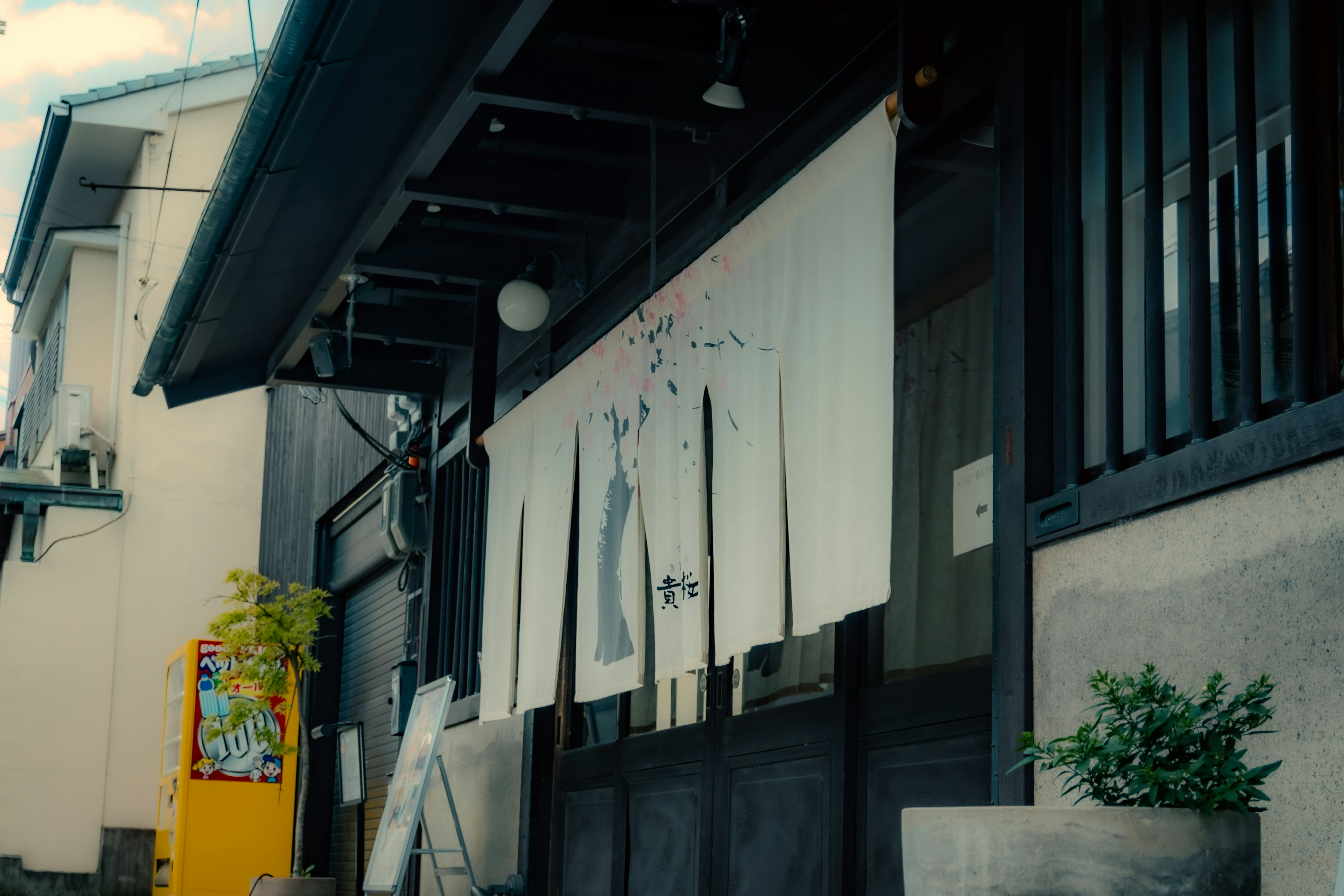 Exterior of a traditional Japanese building featuring art and plants