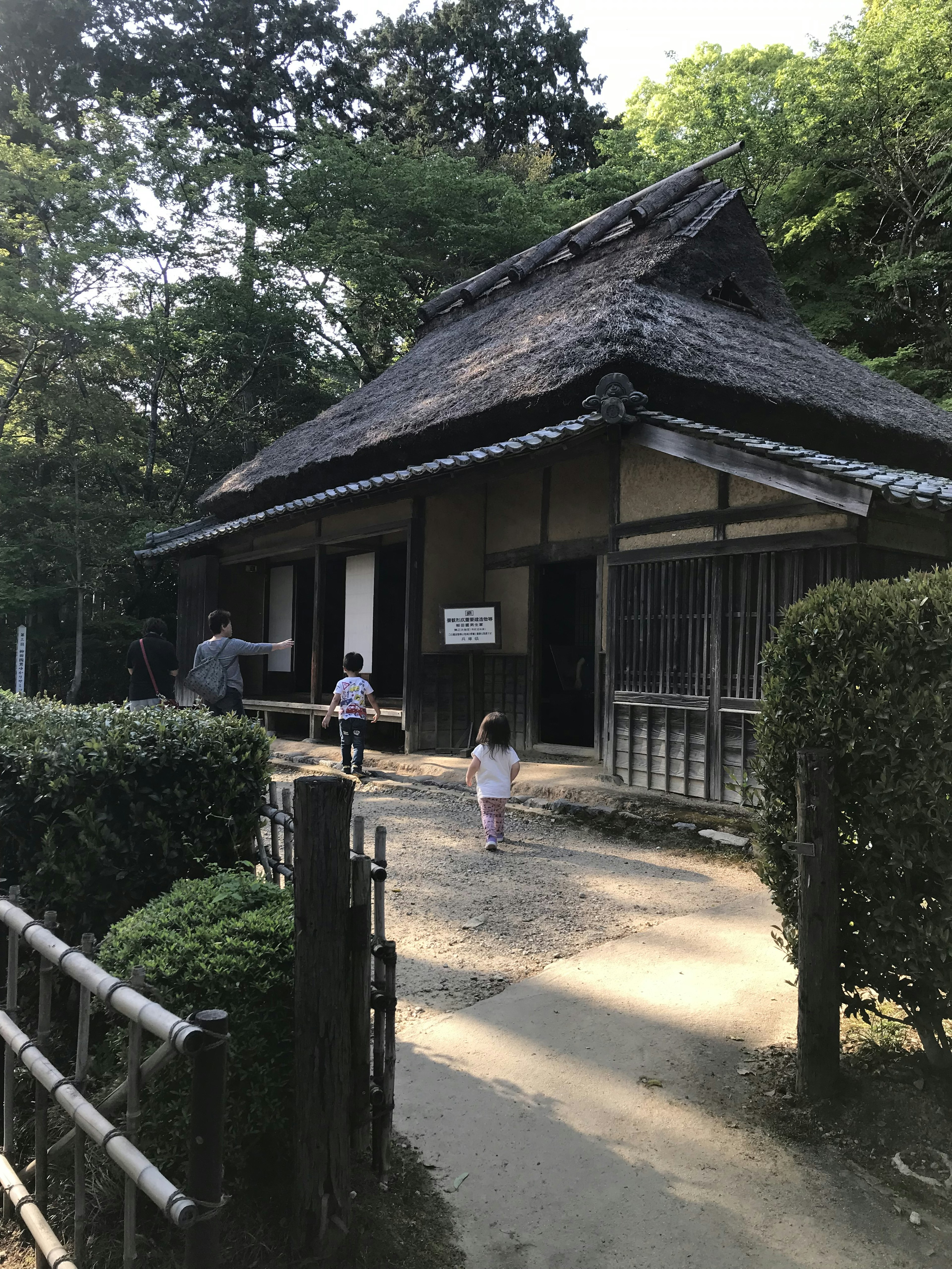 Maison traditionnelle japonaise avec des enfants jouant à proximité