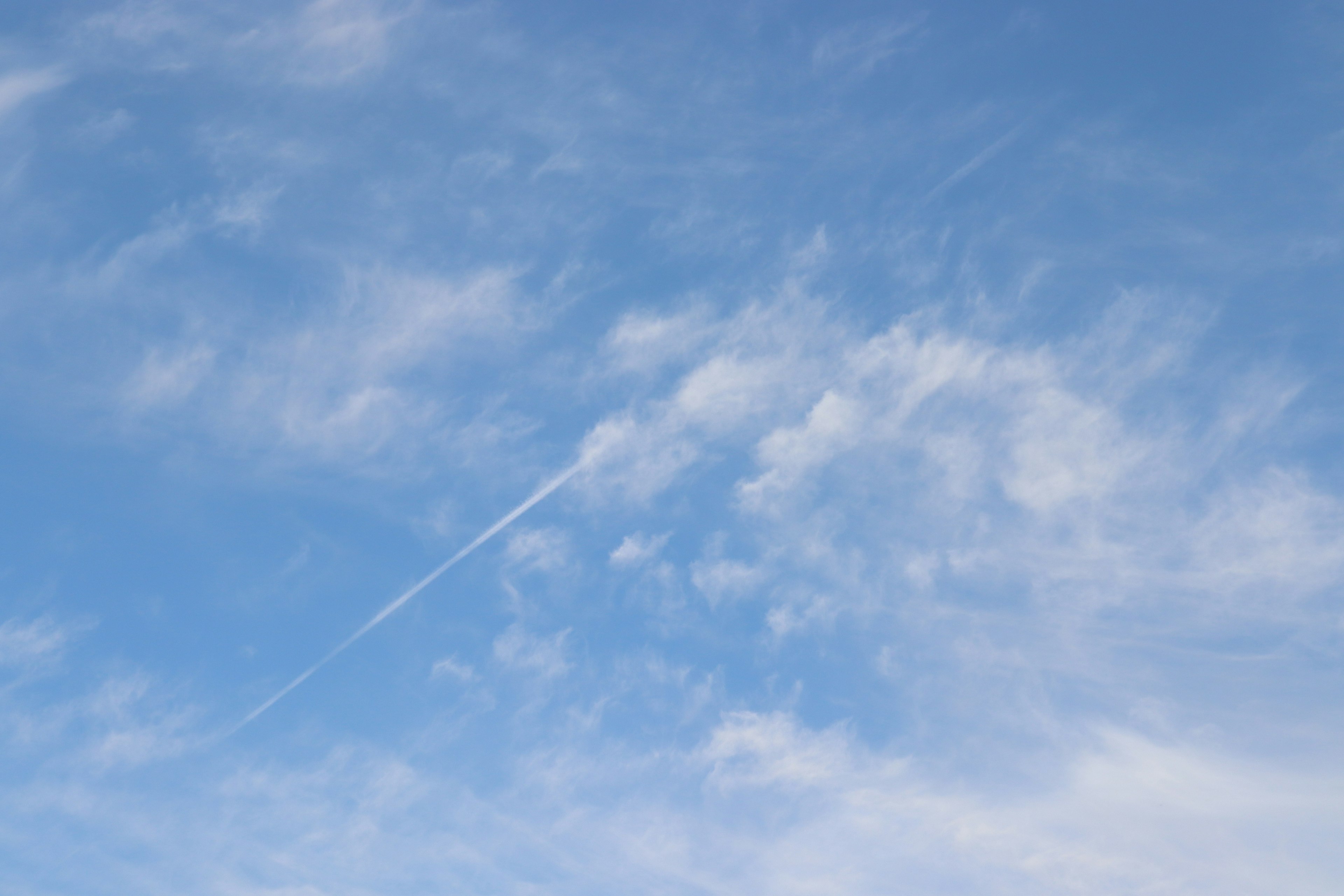 Un ciel bleu clair avec des nuages blancs épars