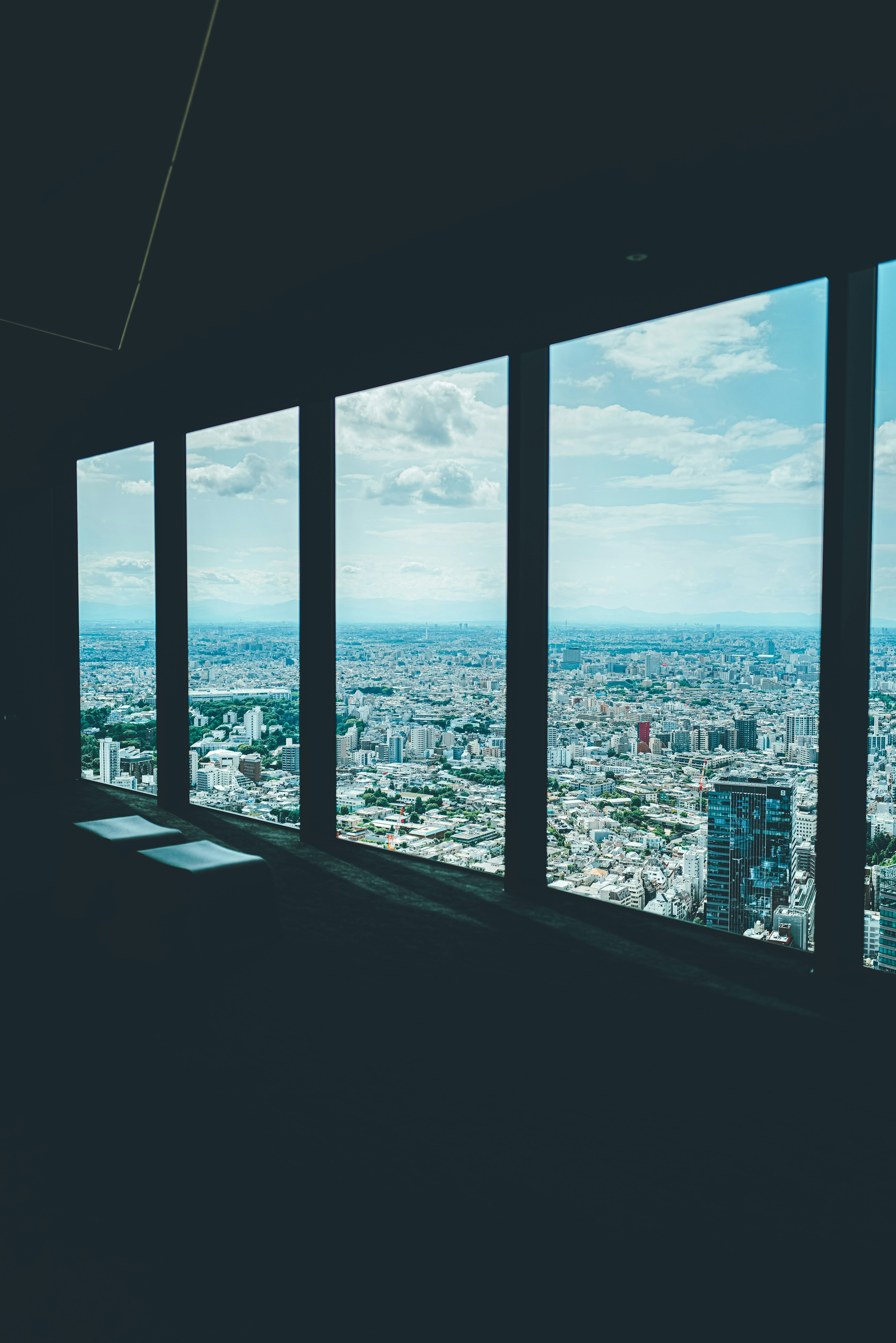 Vista della città da una finestra di un grattacielo con cielo blu e nuvole