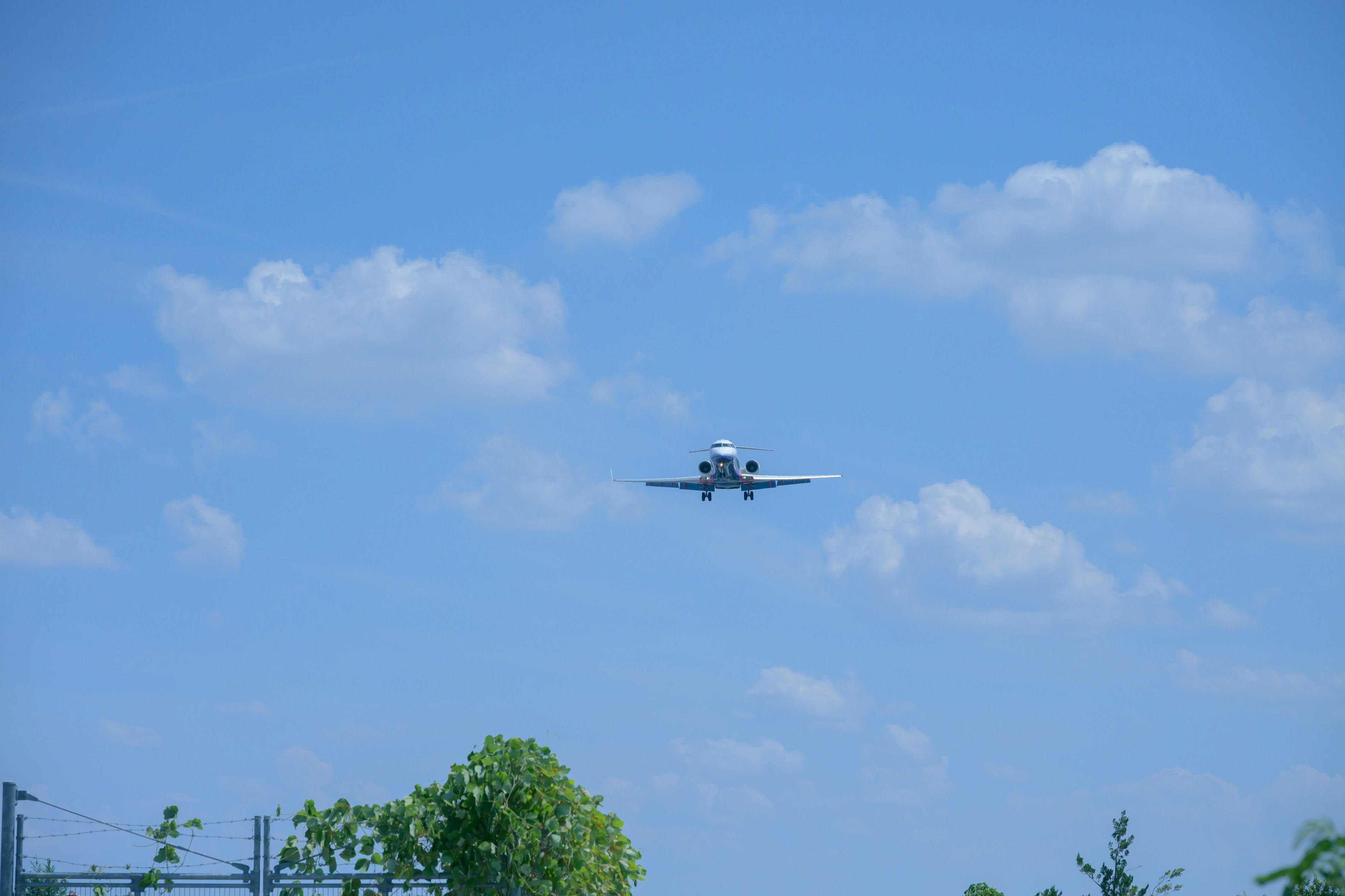 Ein Flugzeug fliegt gegen einen blauen Himmel mit Wolken