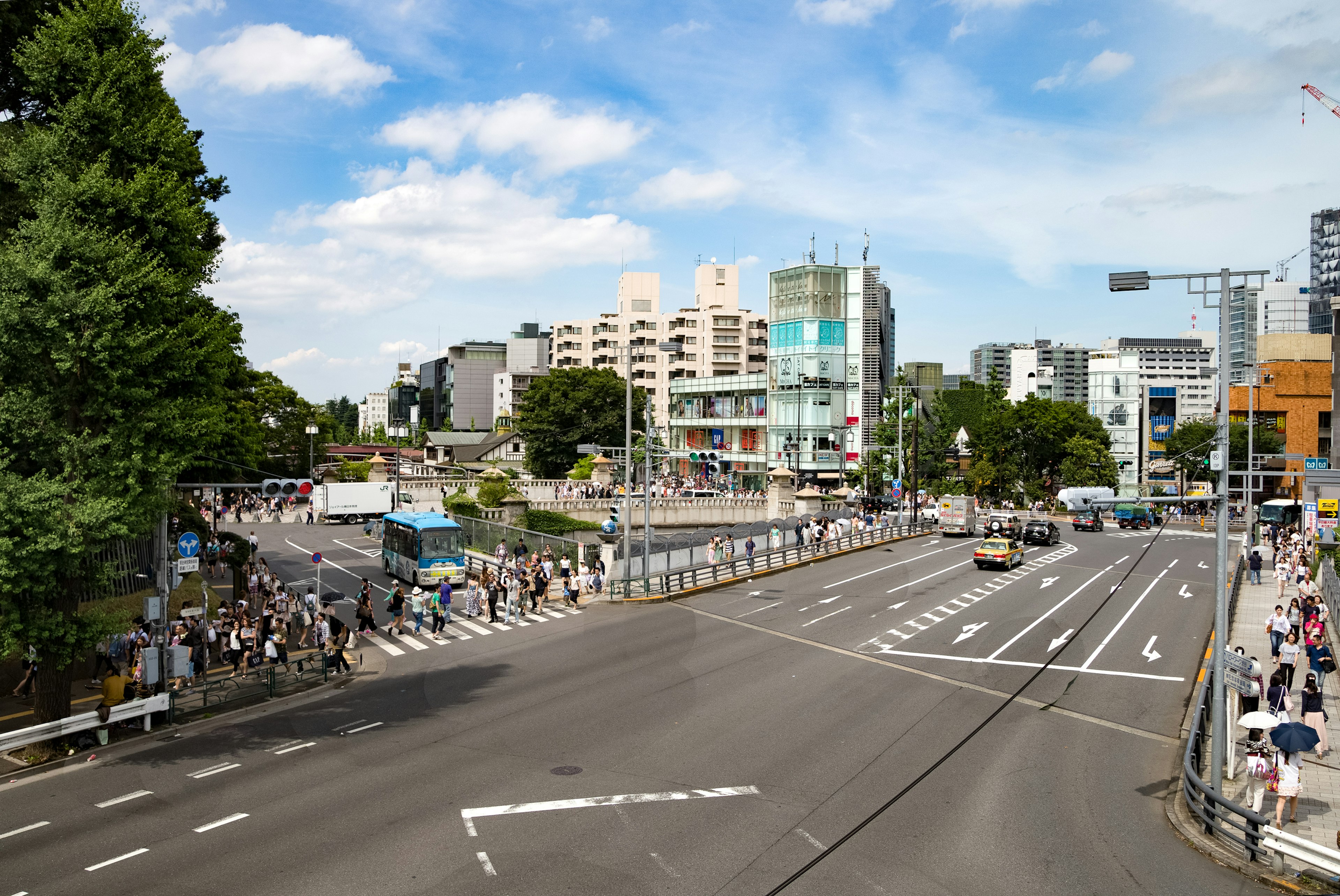 Städtische Landschaft unter blauem Himmel mit Verkehr und Fußgängern