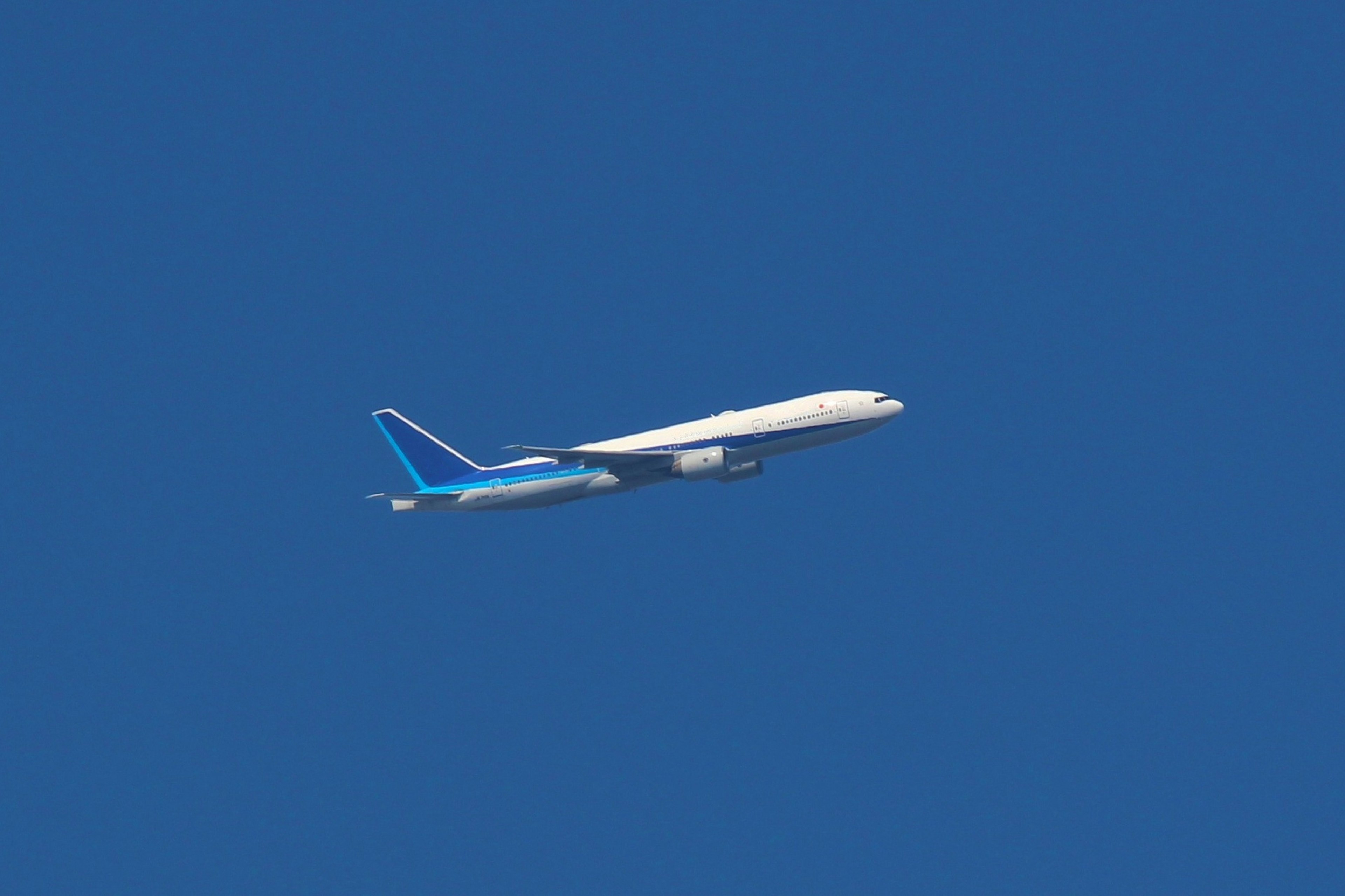 White airplane flying in a clear blue sky