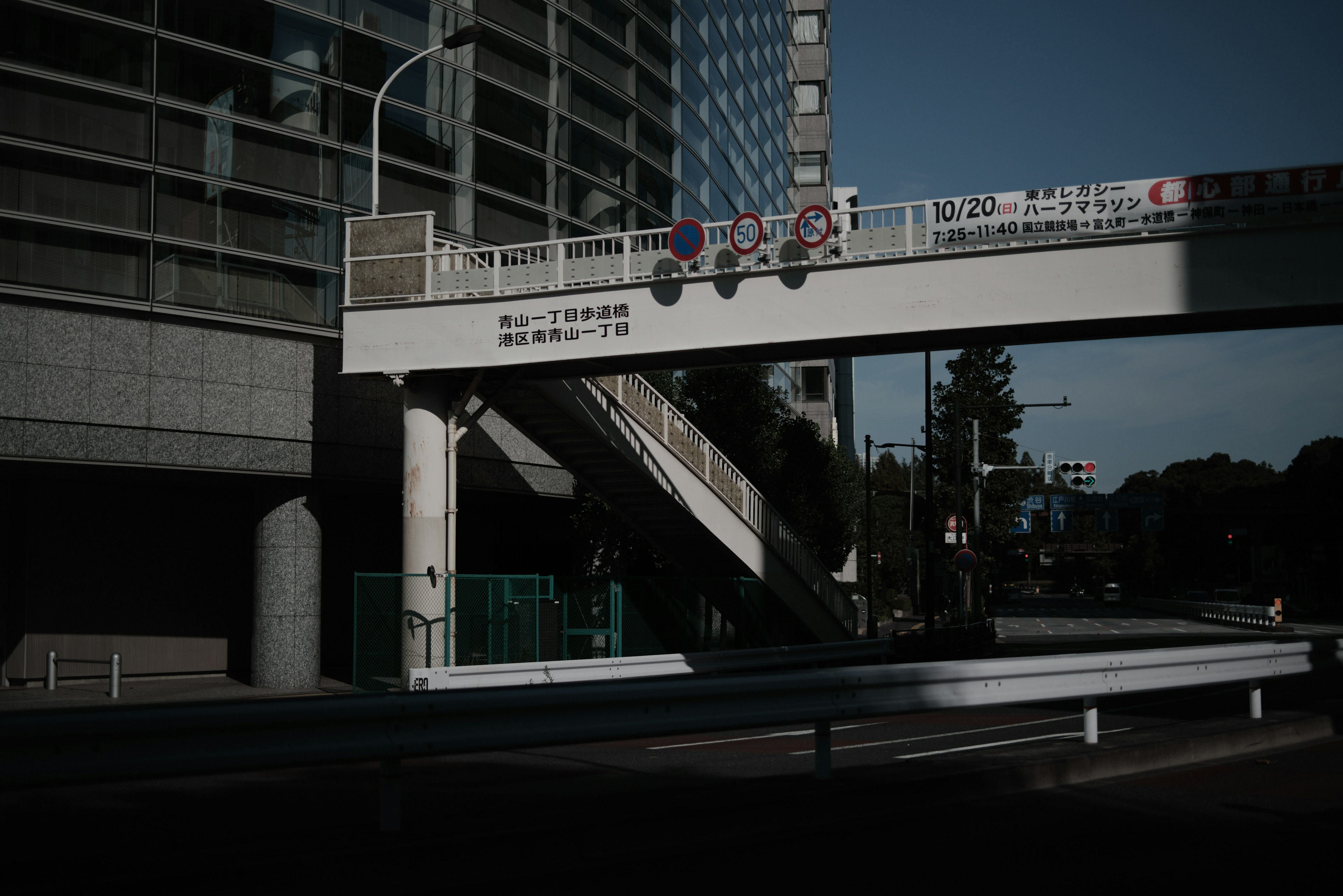 Eine dunkle städtische Szene mit einem erhöhten Gehweg und Gebäuden