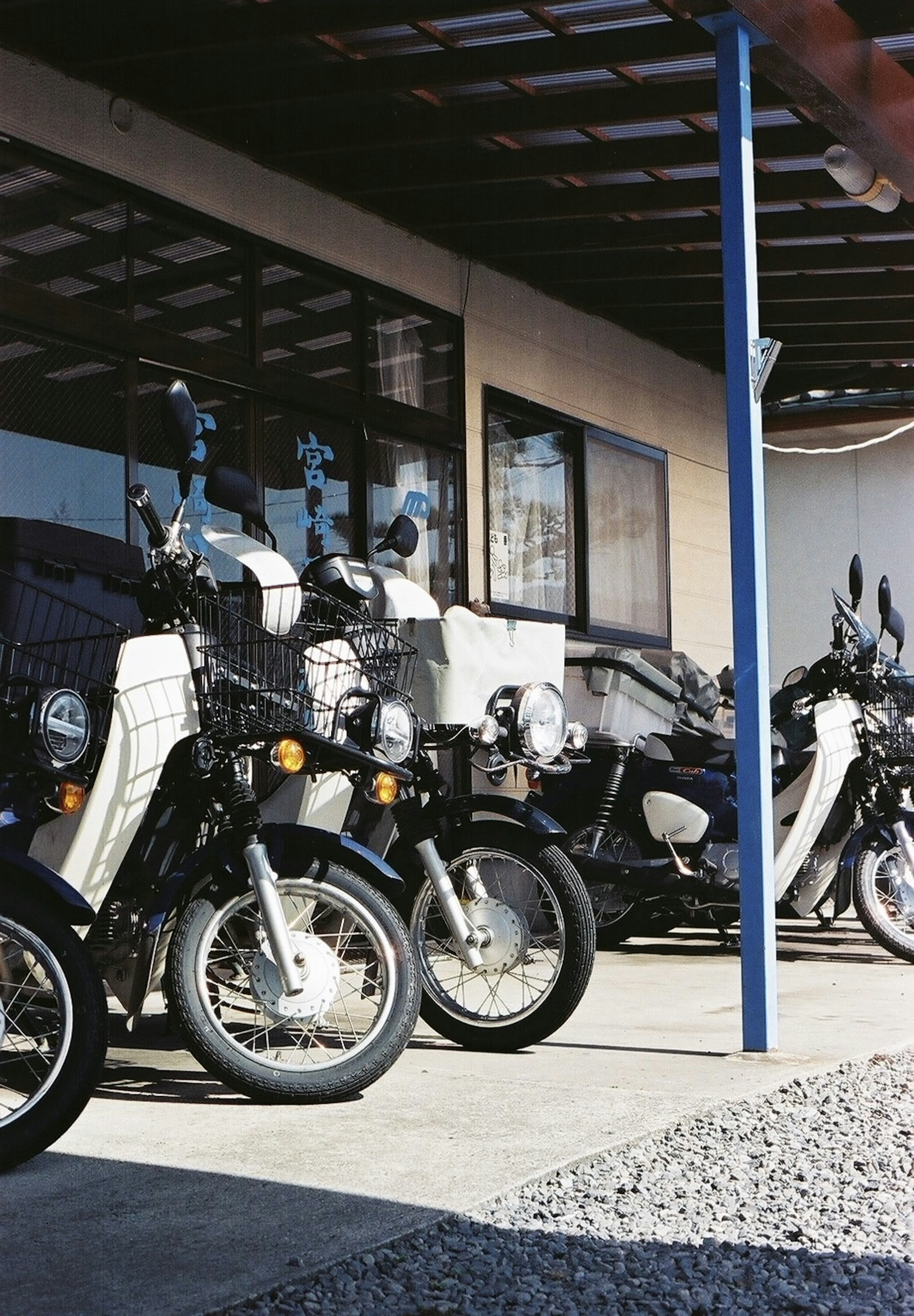 Rangée de motos noires et blanches garées devant un garage