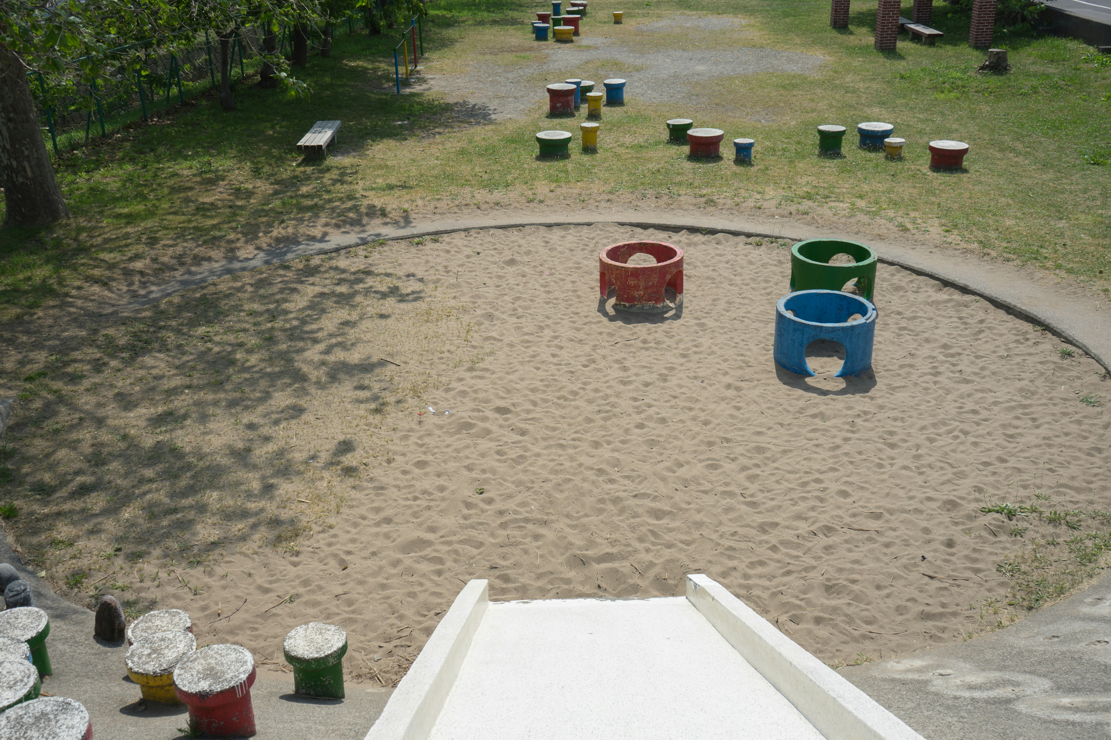 Vista de un parque infantil con área de arena y equipos coloridos