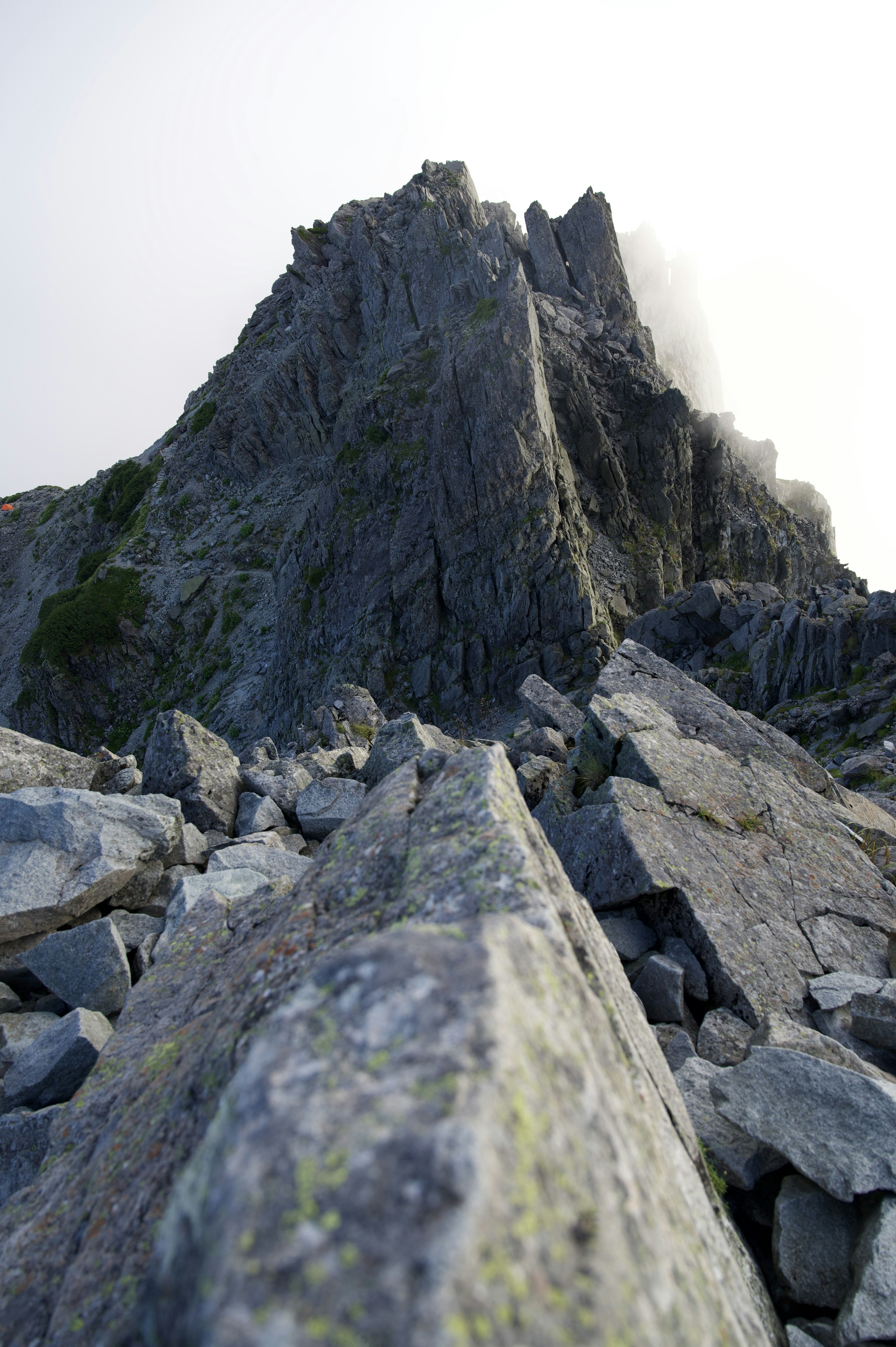 Felsiger Berggipfel mit Blick von der Basis Eingehüllt in Nebel und raue Texturen