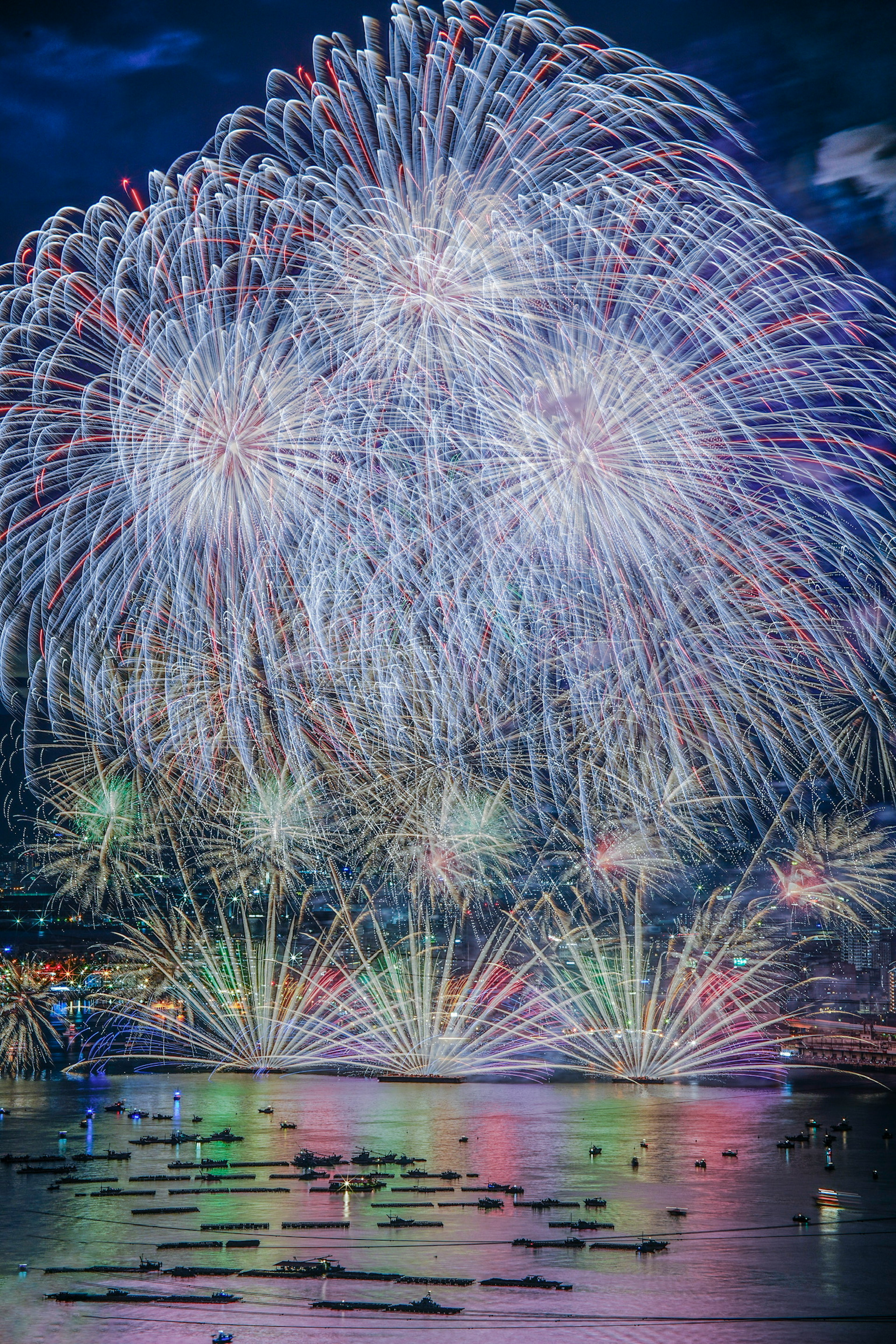 夜空を彩る華やかな花火が水面に反射する美しい光景