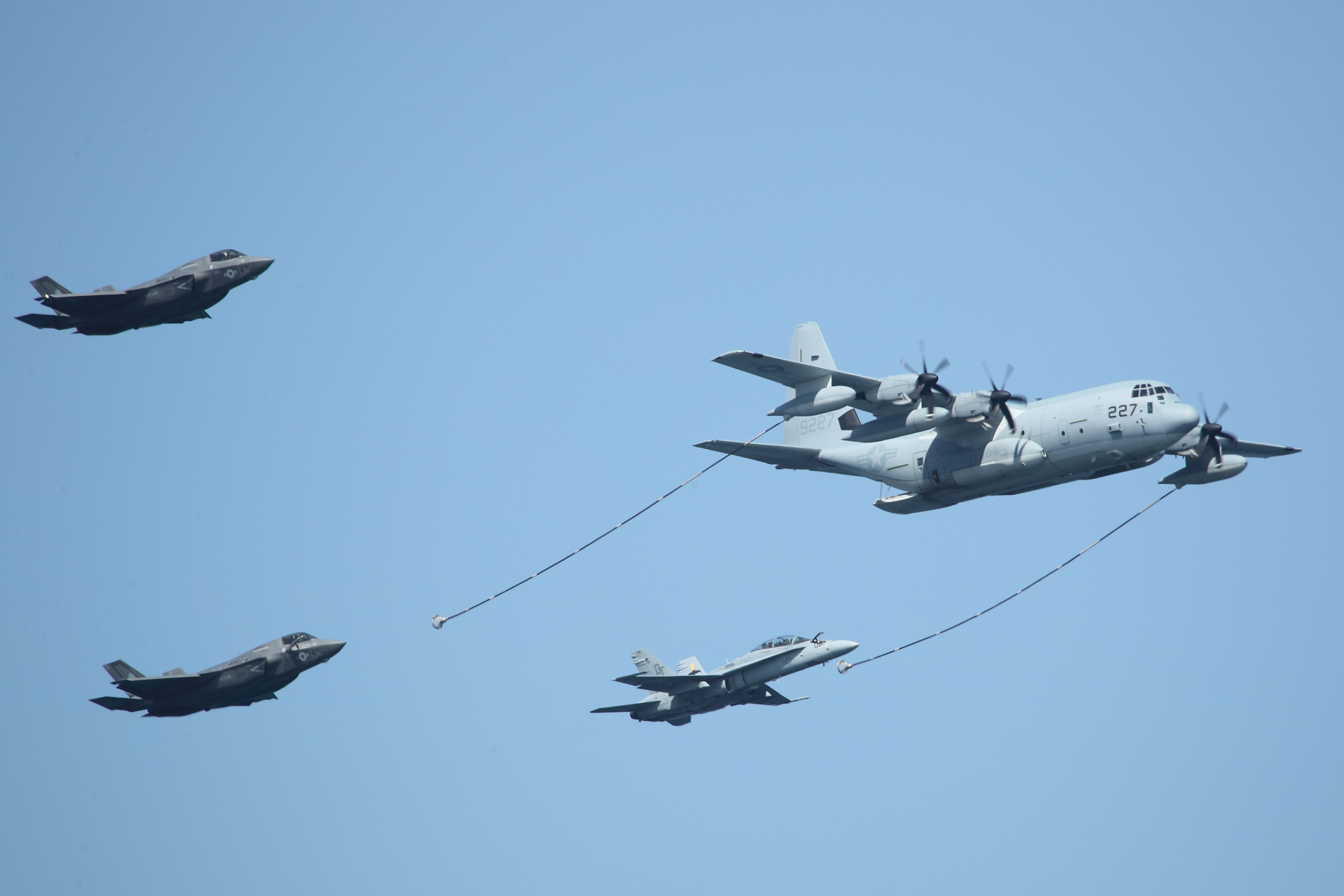 A formation of military aircraft conducting aerial refueling