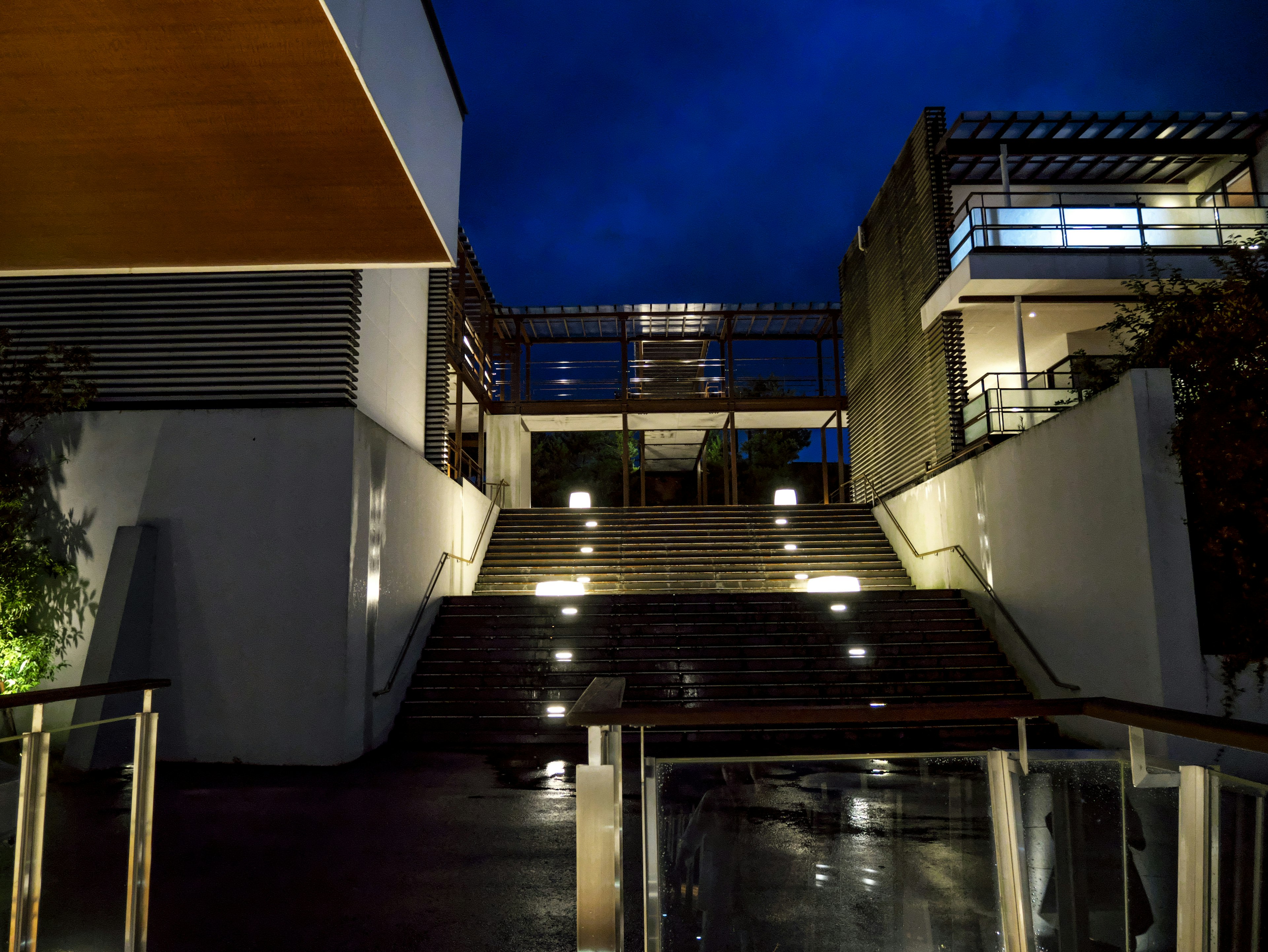 Vista nocturna de un edificio con escaleras iluminadas y arquitectura moderna