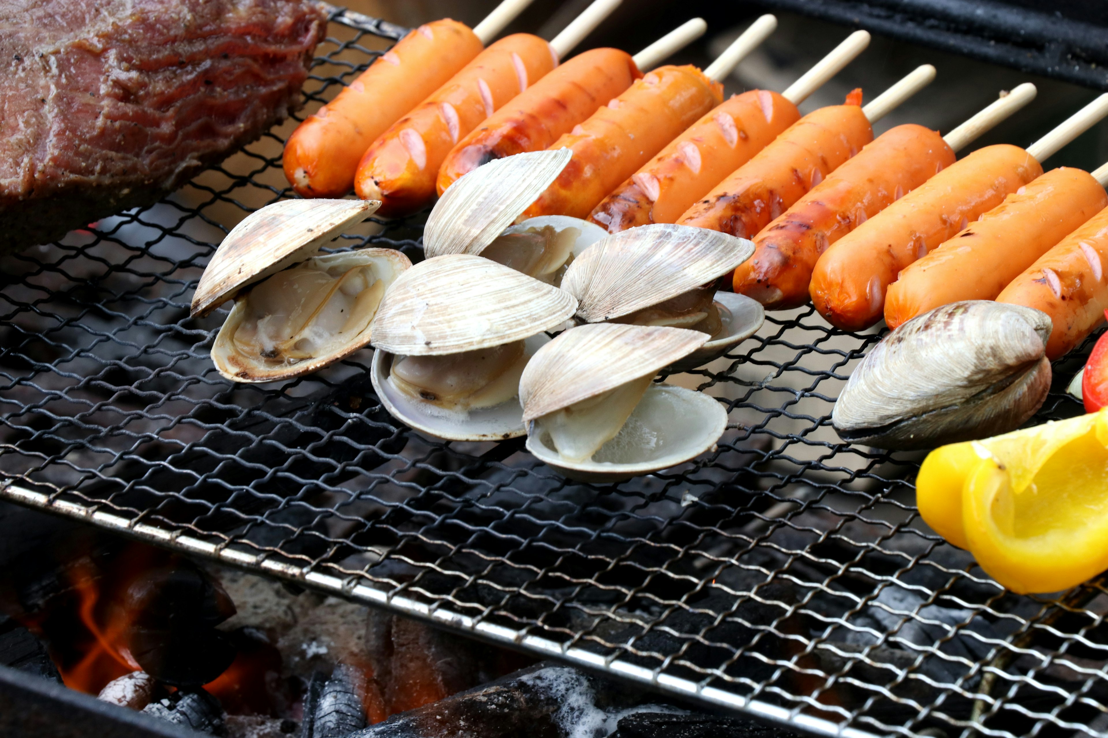 Grill mit gegrilltem Fleisch Würstchen und Muscheln