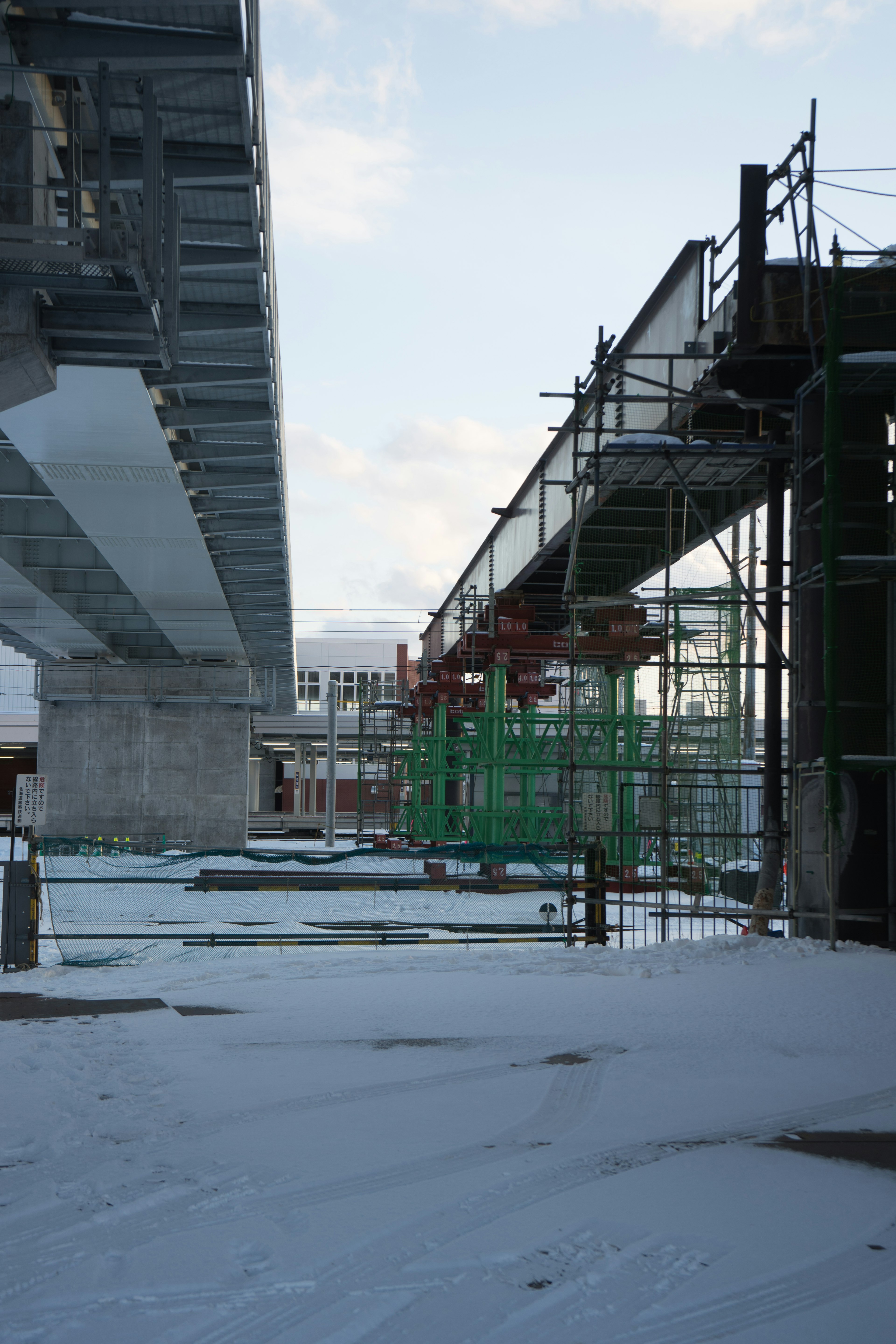 Chantier de construction avec un pont et des échafaudages recouverts de neige