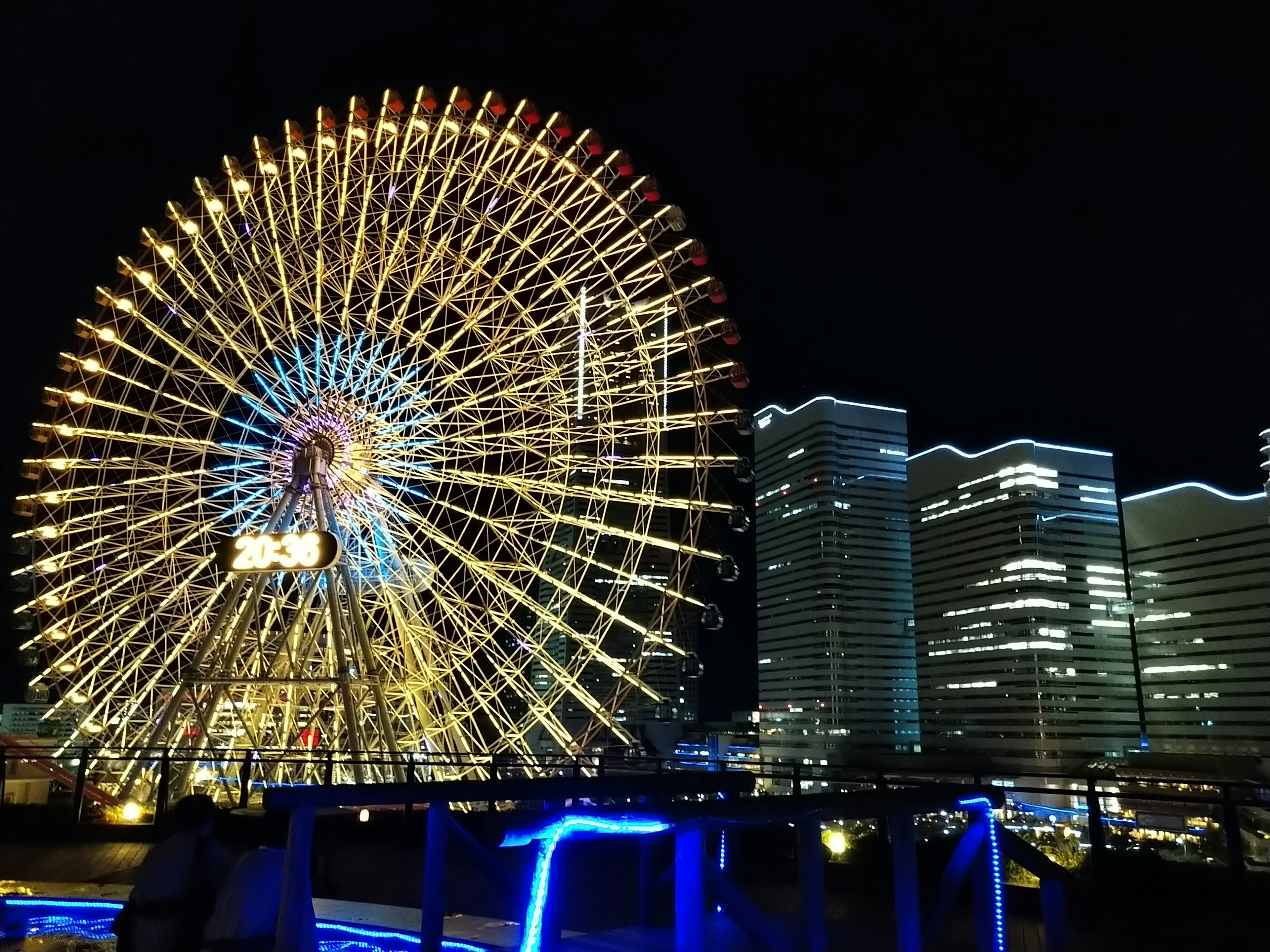 Belle vue d'une grande roue et de gratte-ciels la nuit