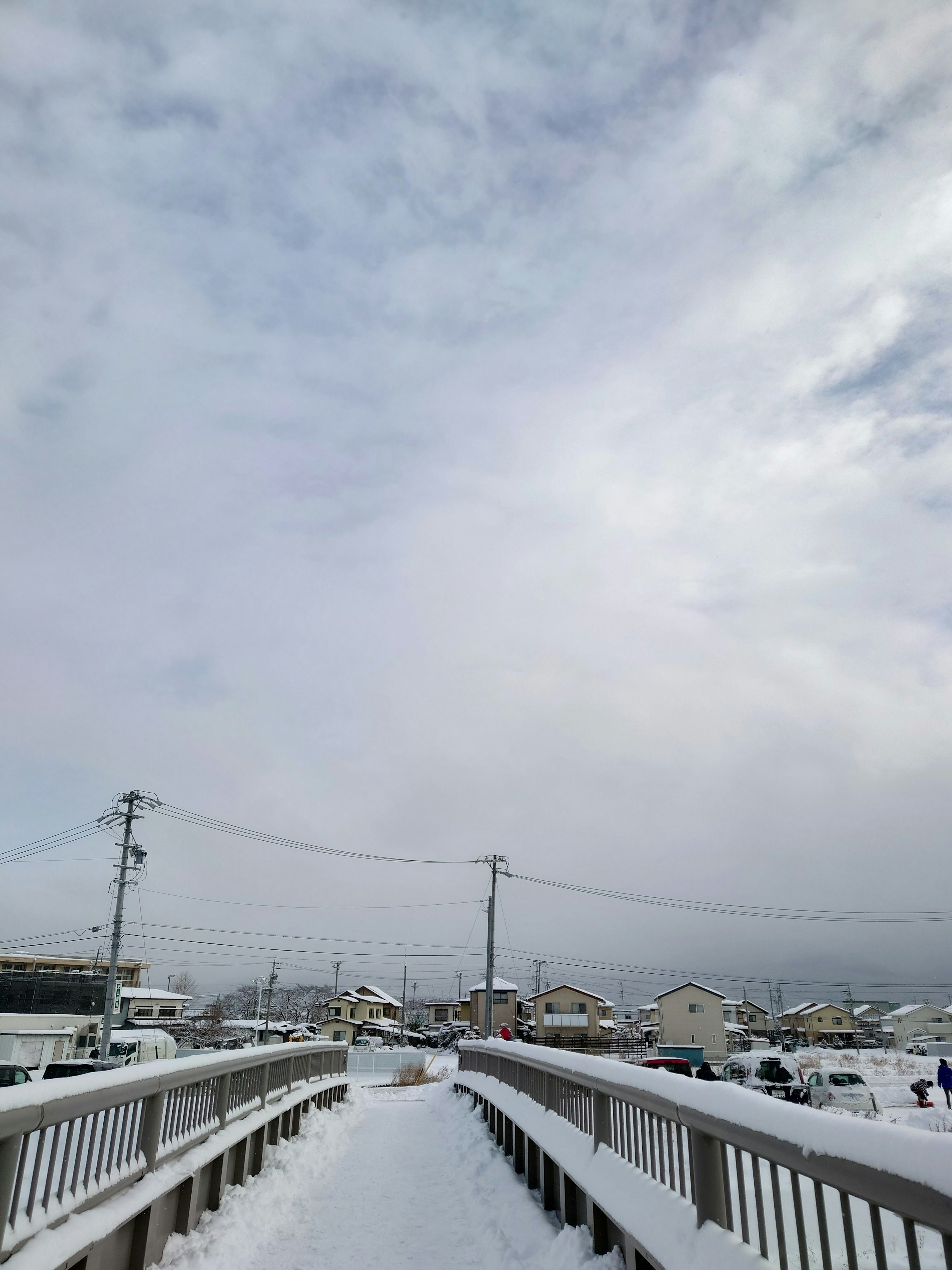 雪に覆われた歩道橋と低い雲