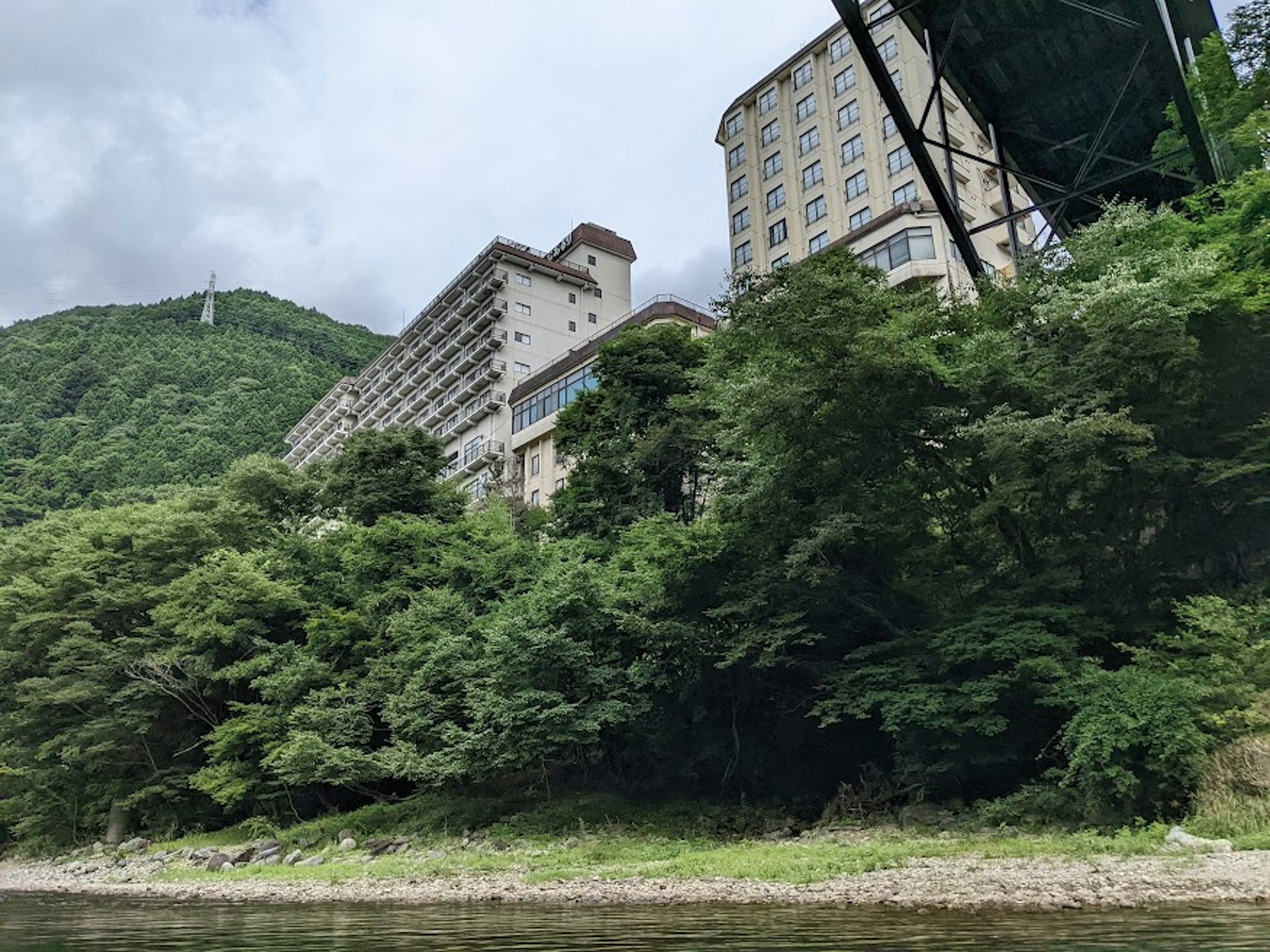 川の近くに立つ高級ホテルの緑豊かな風景