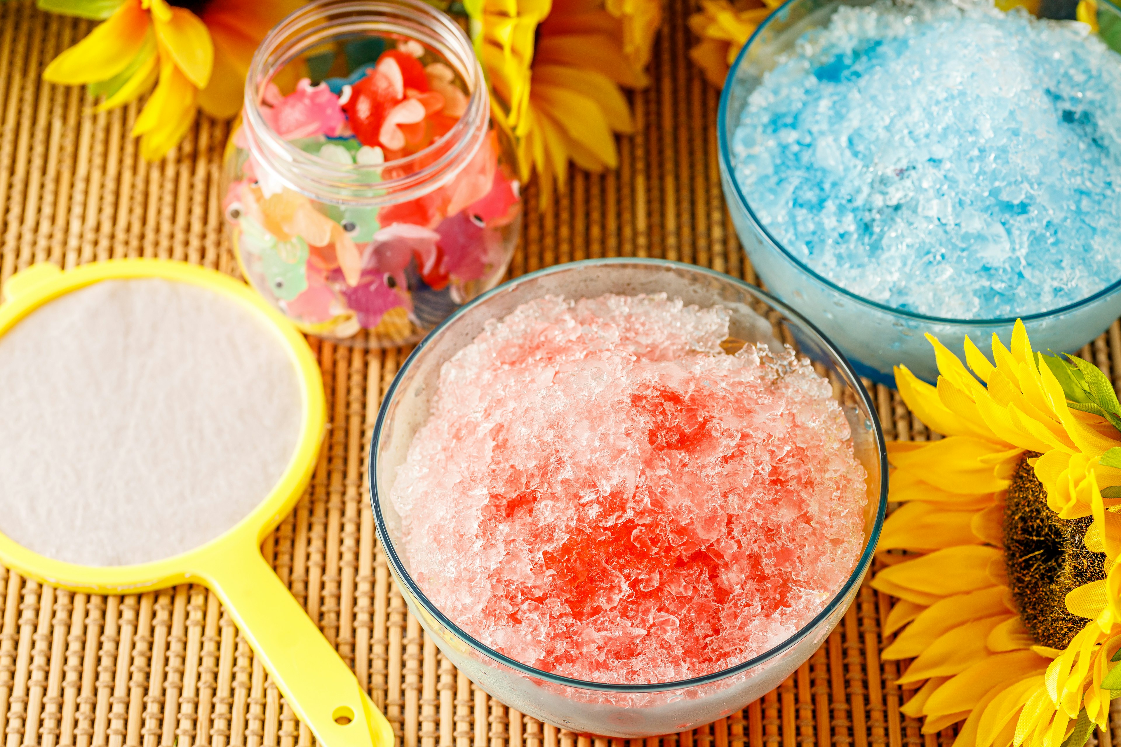 Virutas de hielo coloridas y girasoles en una mesa