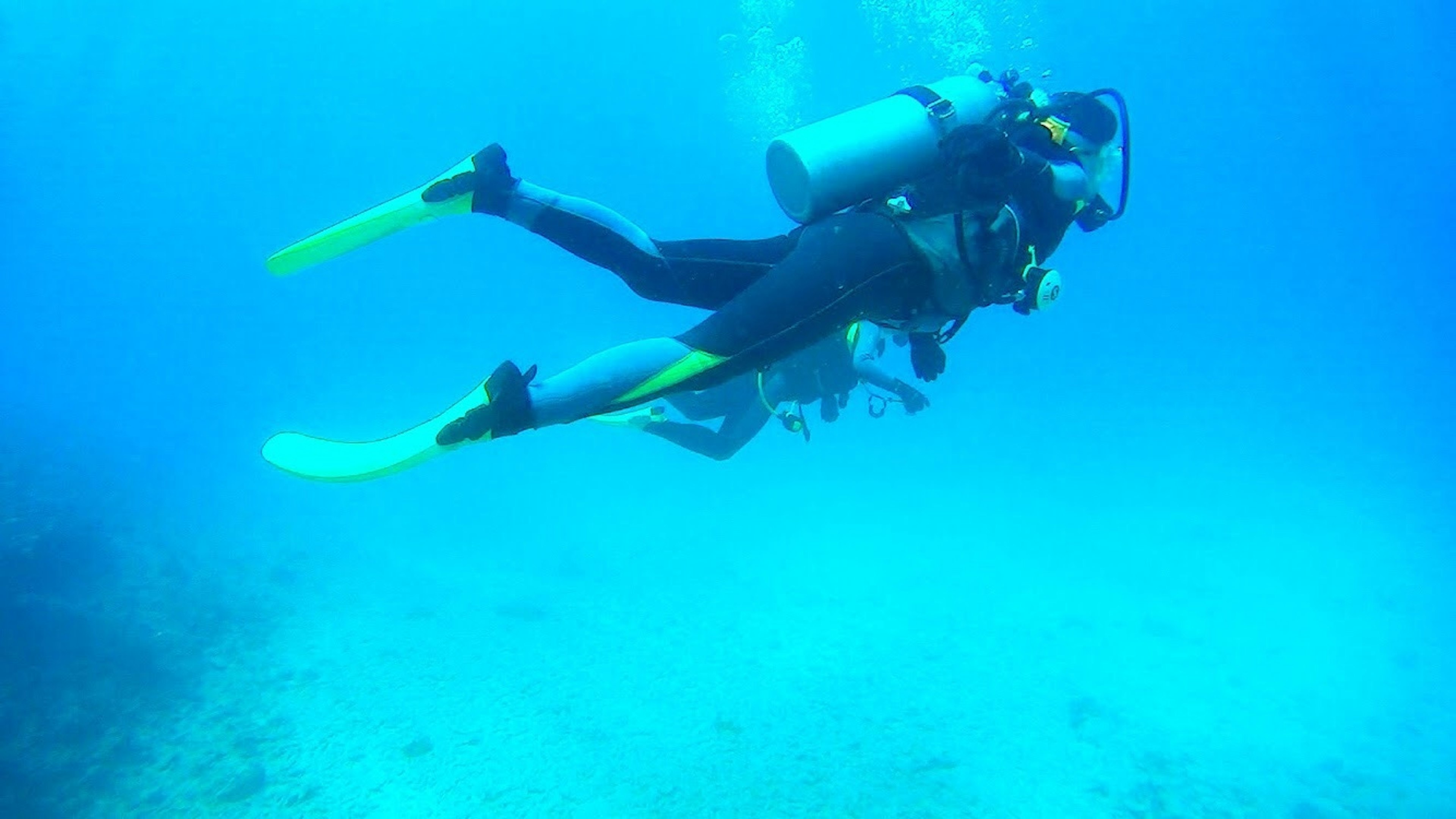 Buceadores nadando bajo el agua en un océano azul