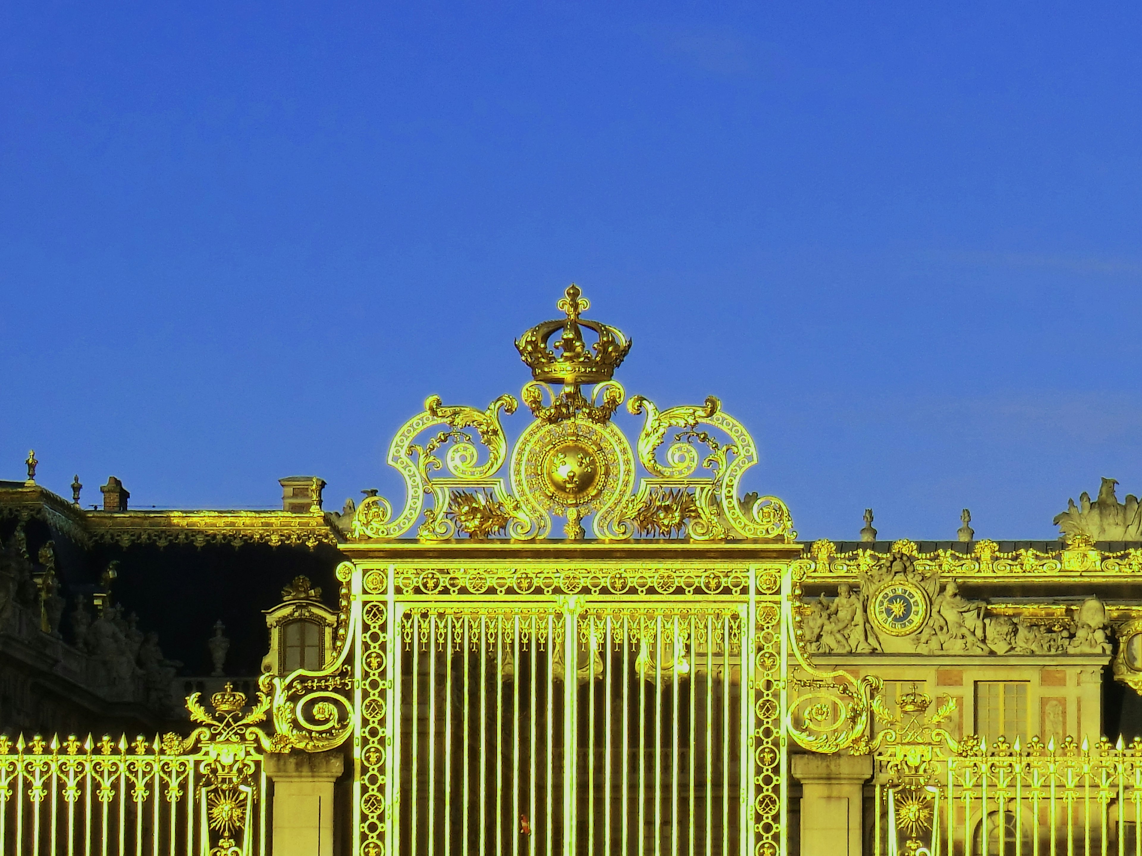 Hermosa puerta con decoraciones doradas y cielo azul