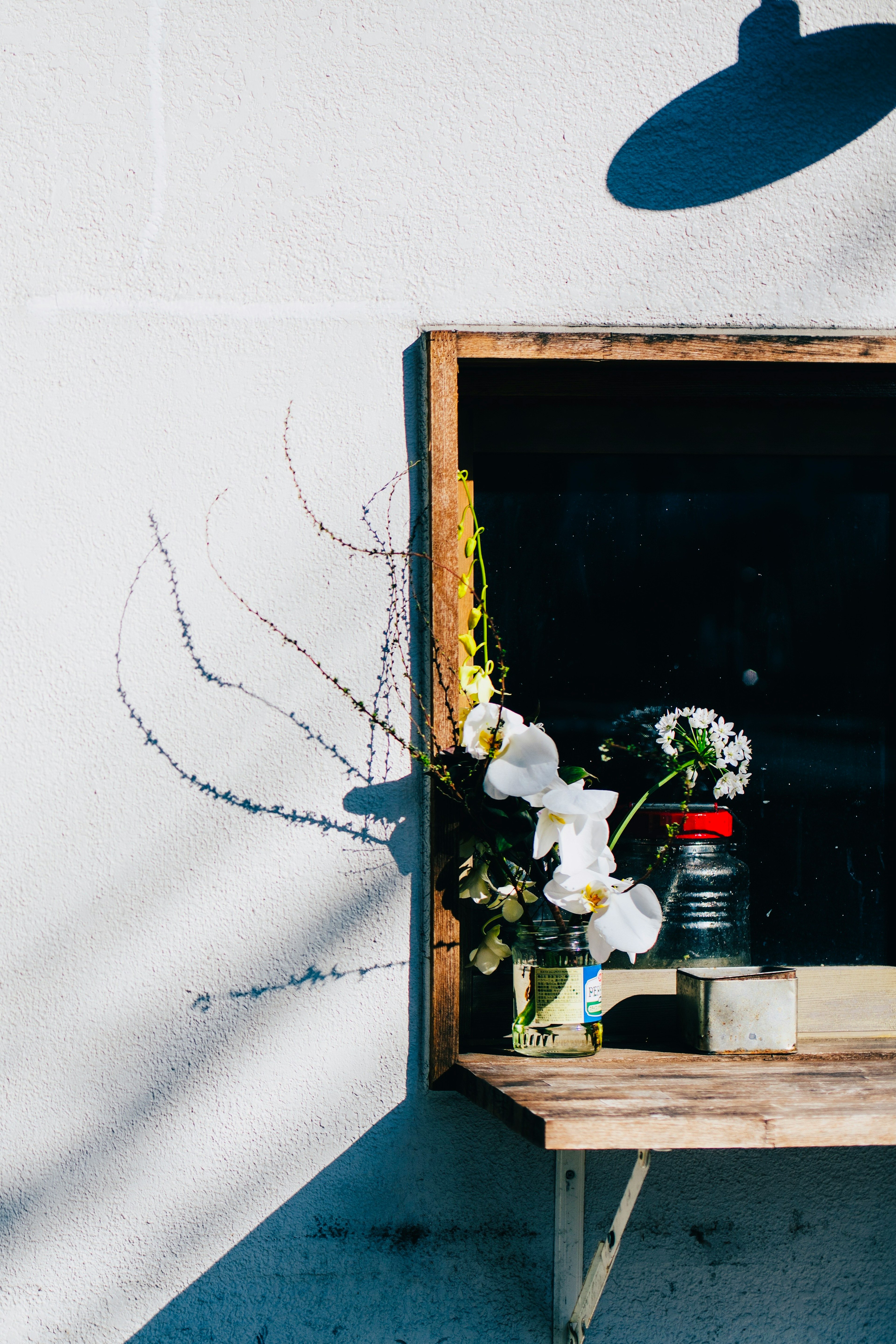 Simple arrangement of vases and candles on a wooden table against a white wall