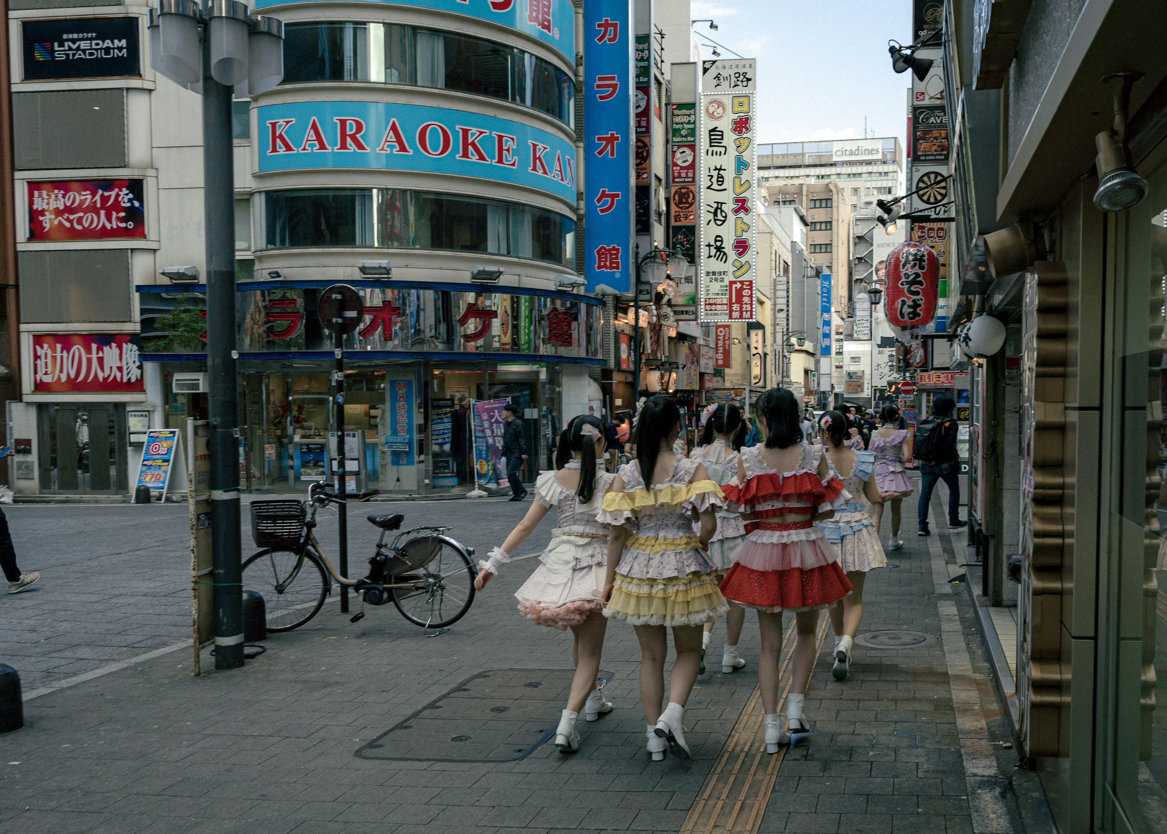 カラフルな衣装を着た少女たちが街を歩いている様子