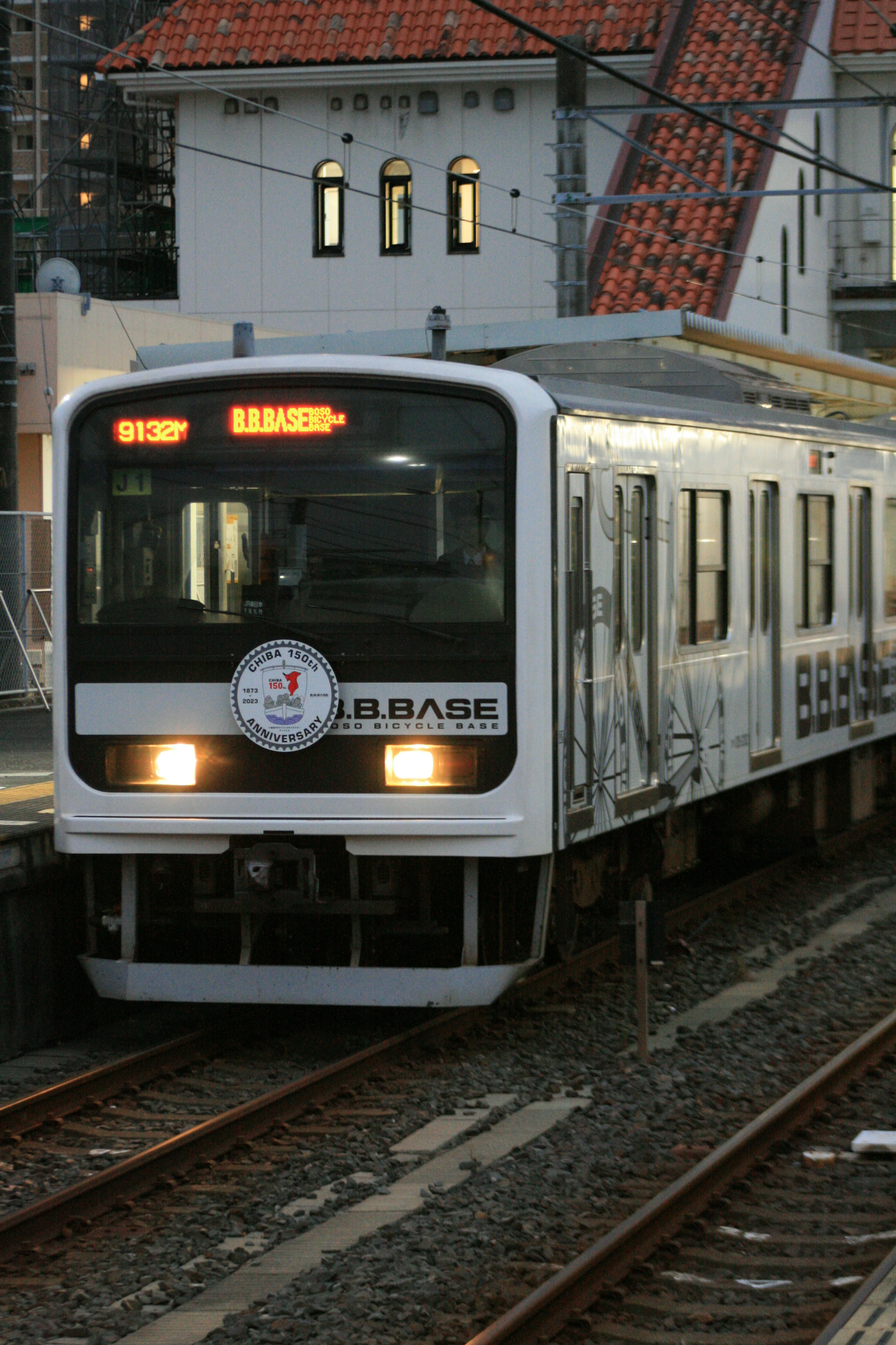 Un treno bianco in arrivo a una stazione con un display chiaro