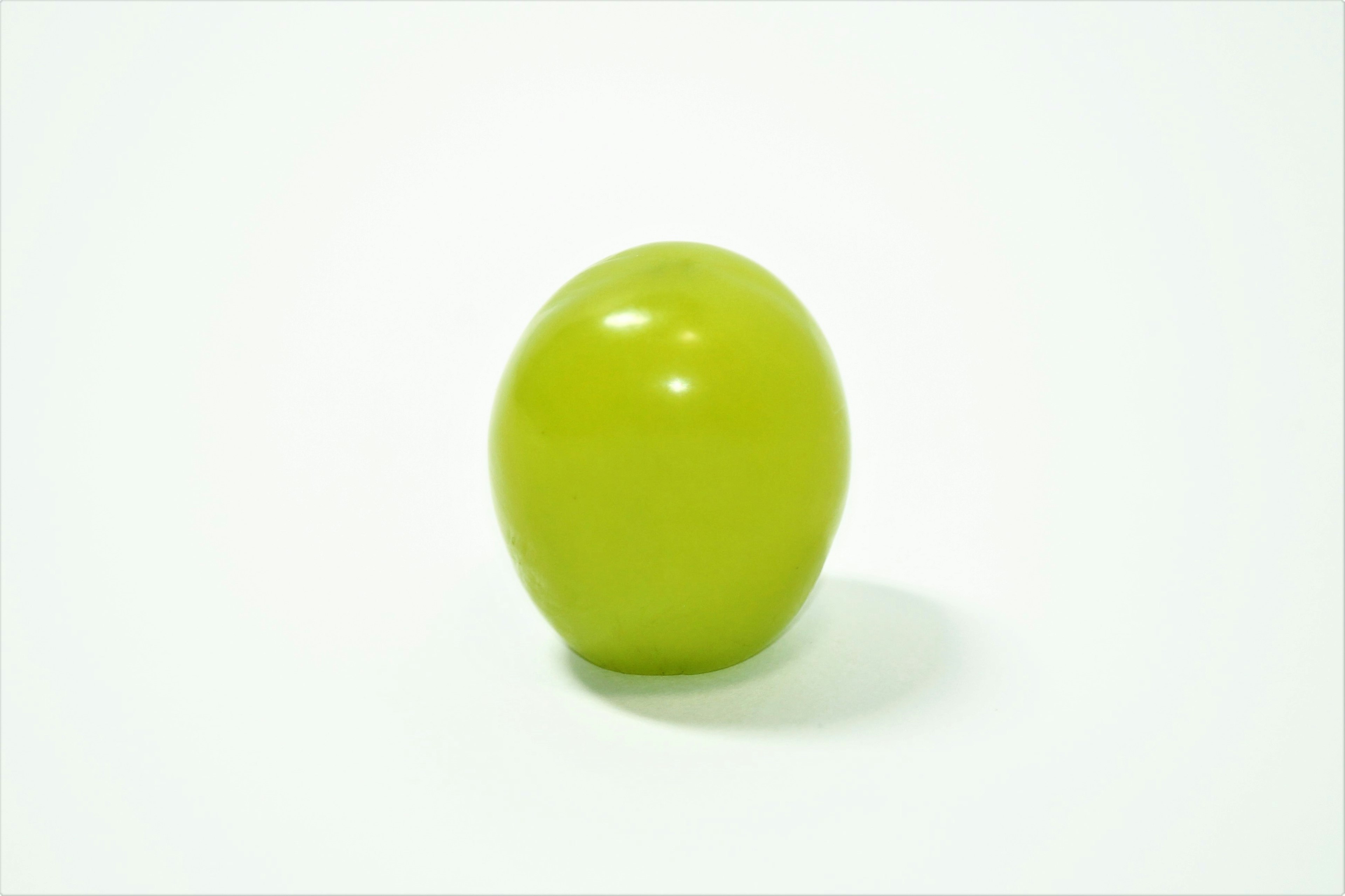 A green egg-shaped object on a white background