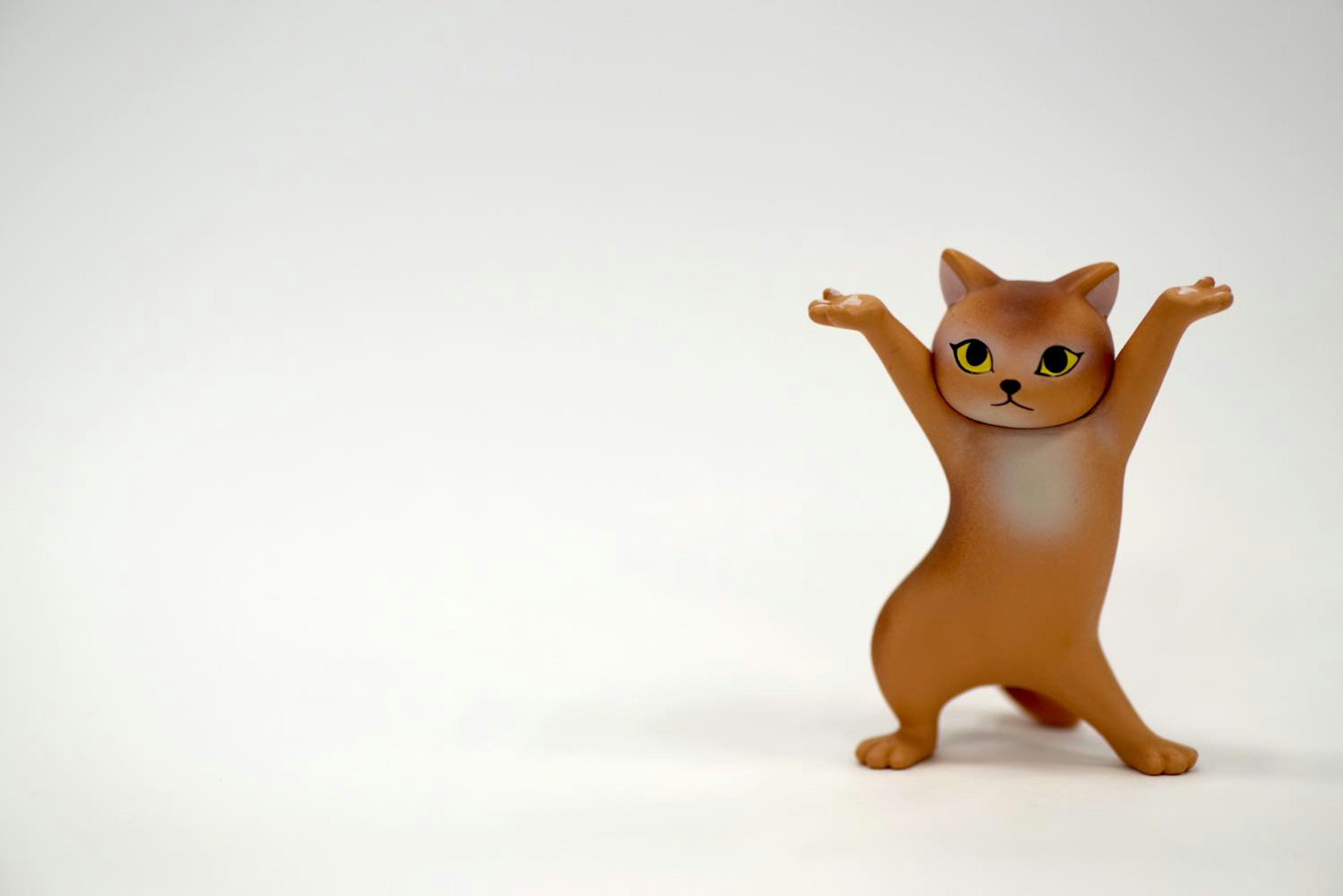 茶色の猫のフィギュアが両手を挙げている