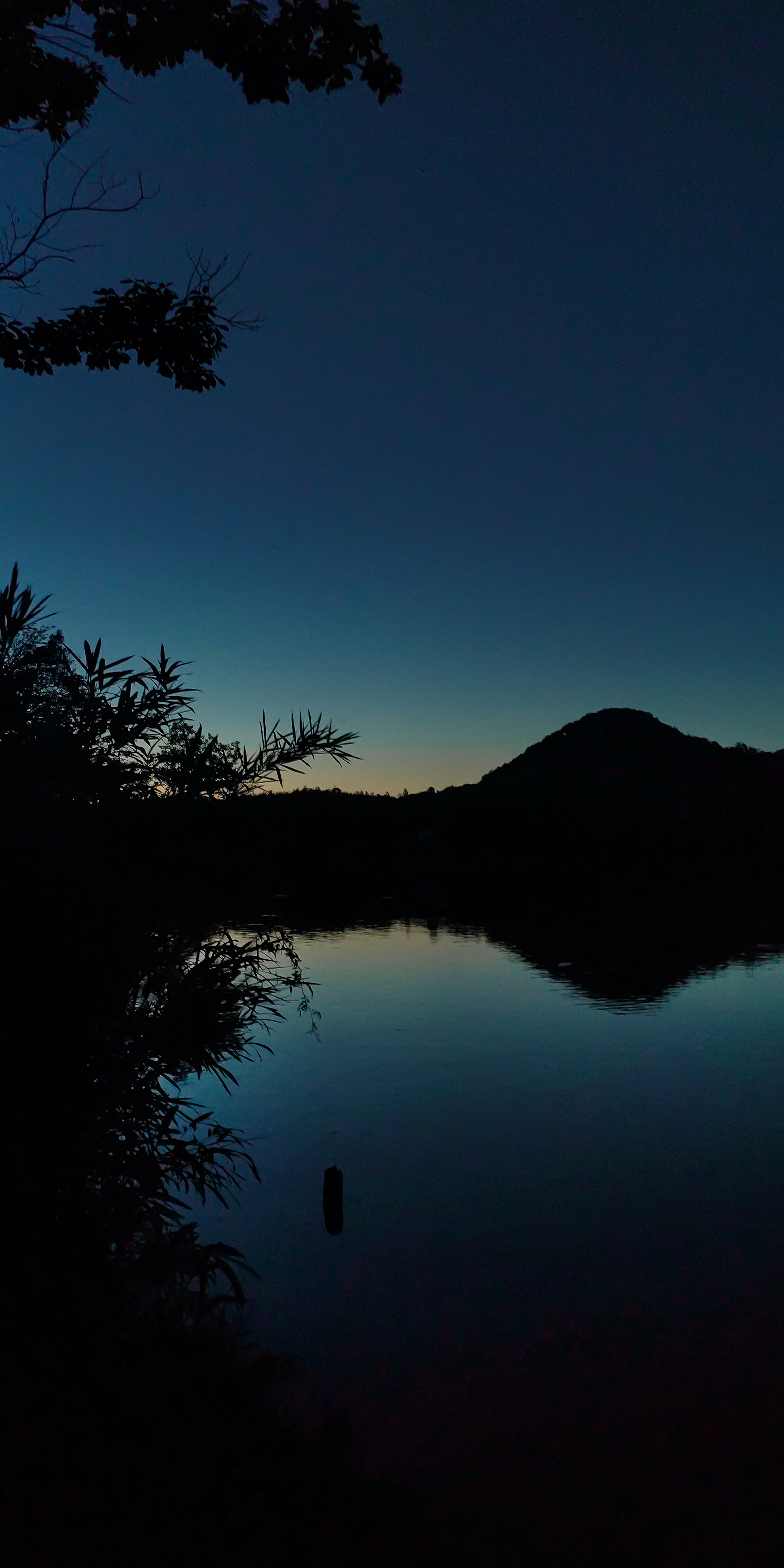 Paysage serein avec lac et silhouette de montagne contre le ciel nocturne