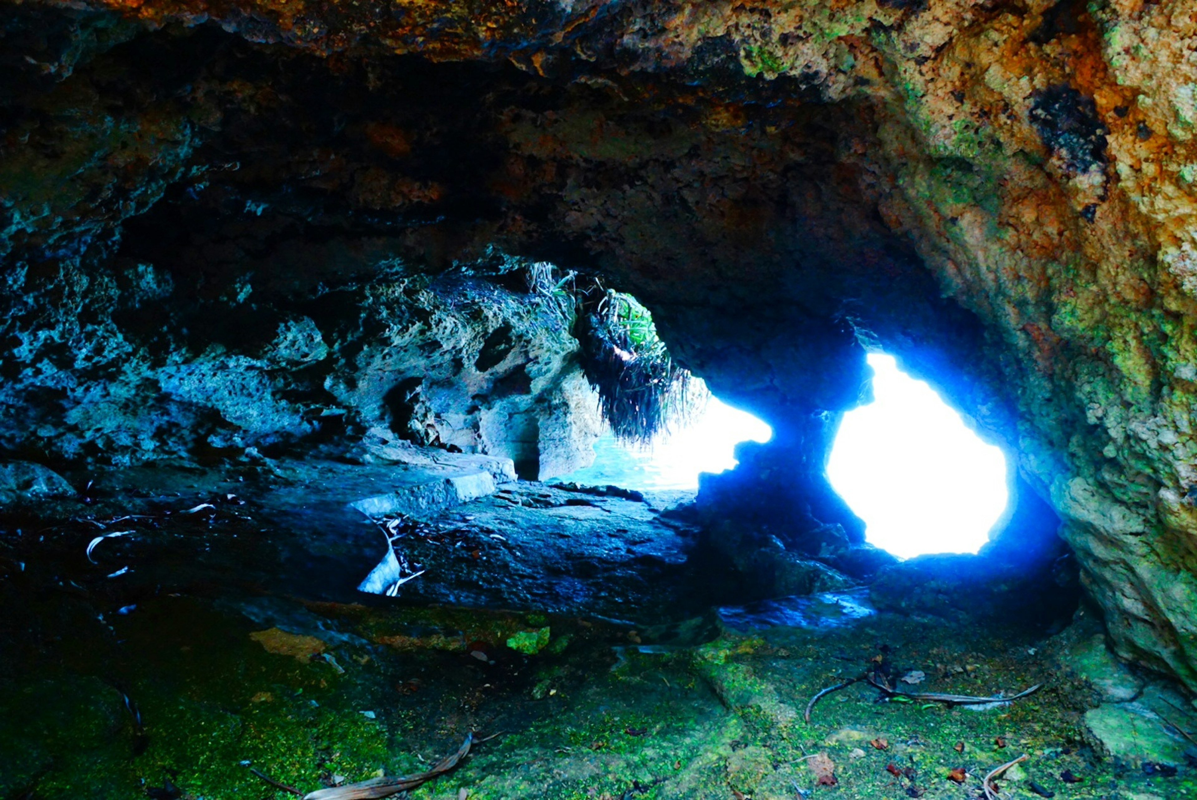 Vista interior de una cueva con luz azul brillando