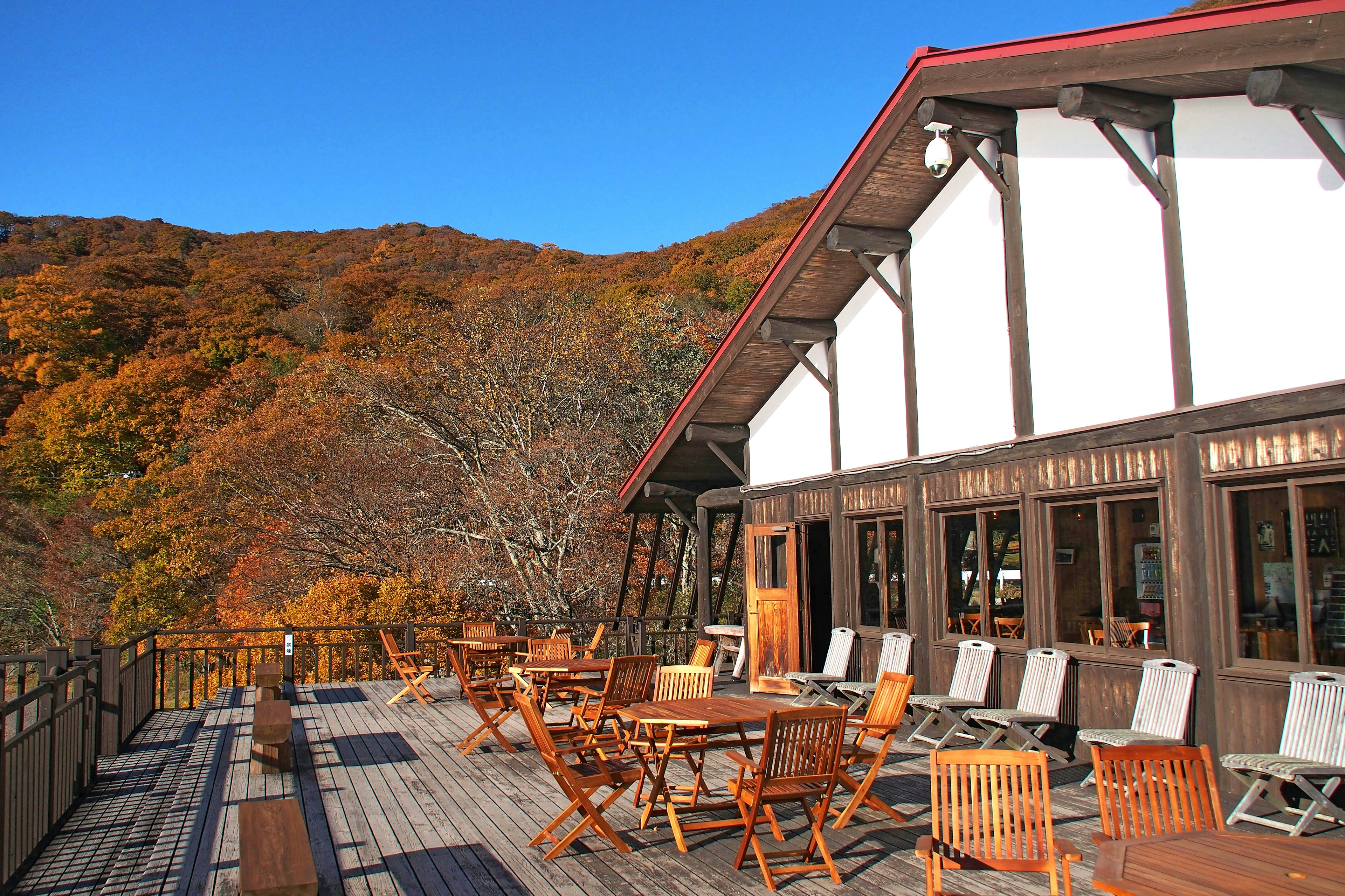 Wooden terrace and seating area with beautiful autumn scenery in the background