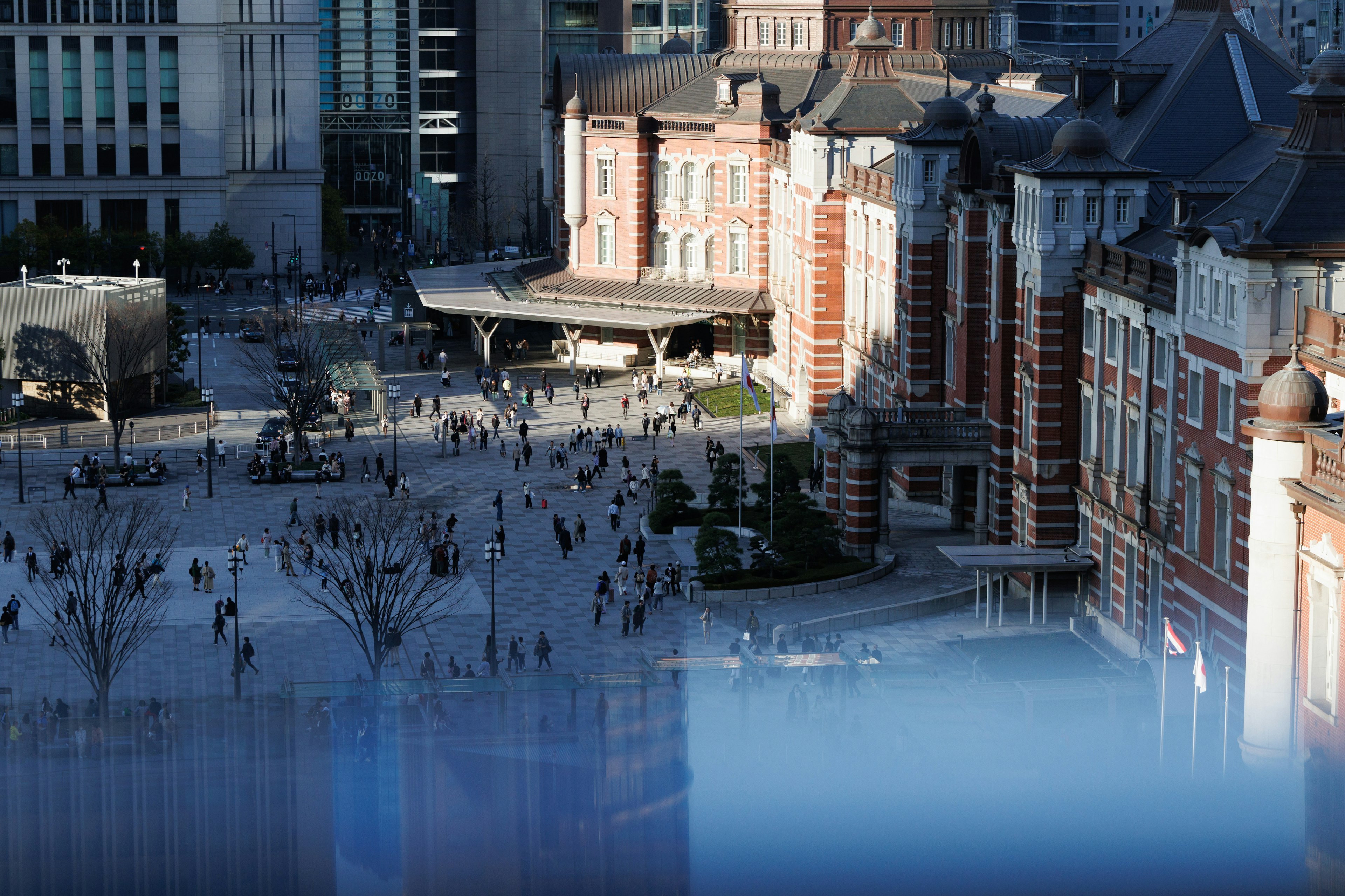 Vue de la gare de Tokyo avec une place animée et des bâtiments historiques