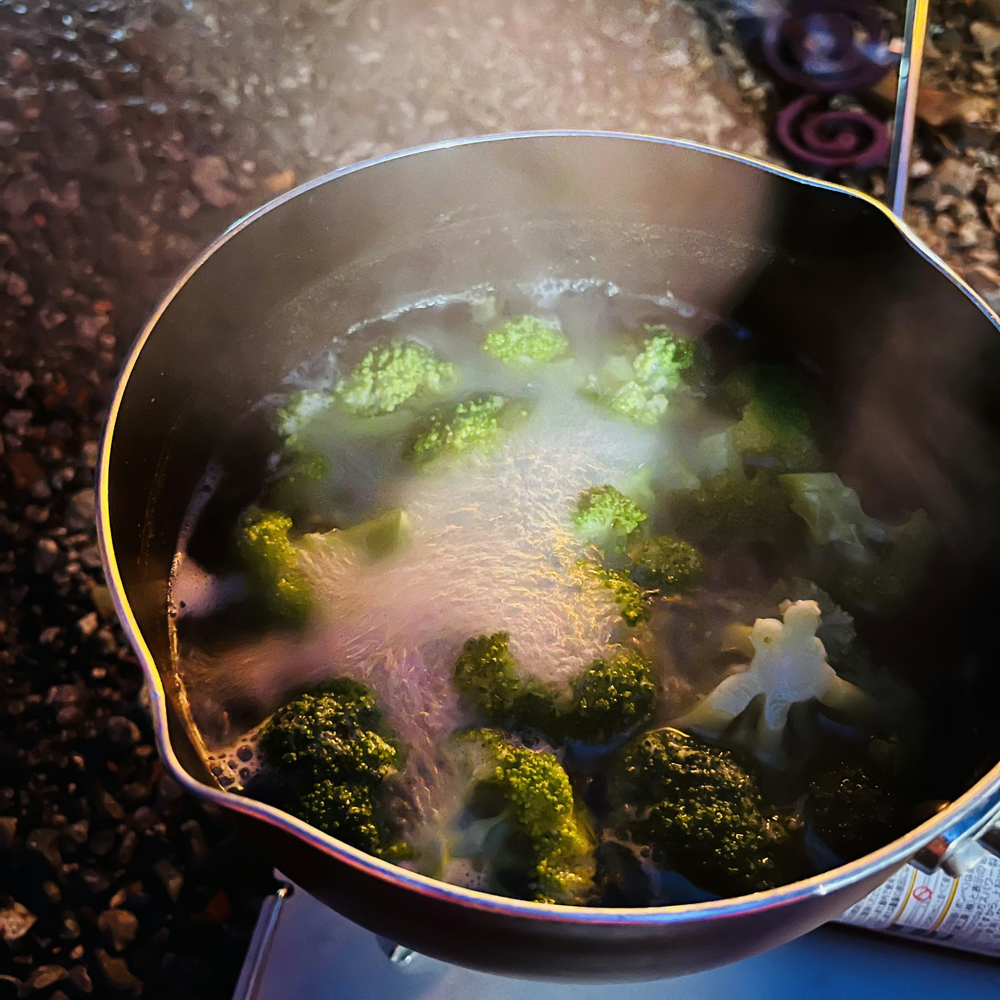 蒸気が立ち上る鍋の中で茹でられているブロッコリー