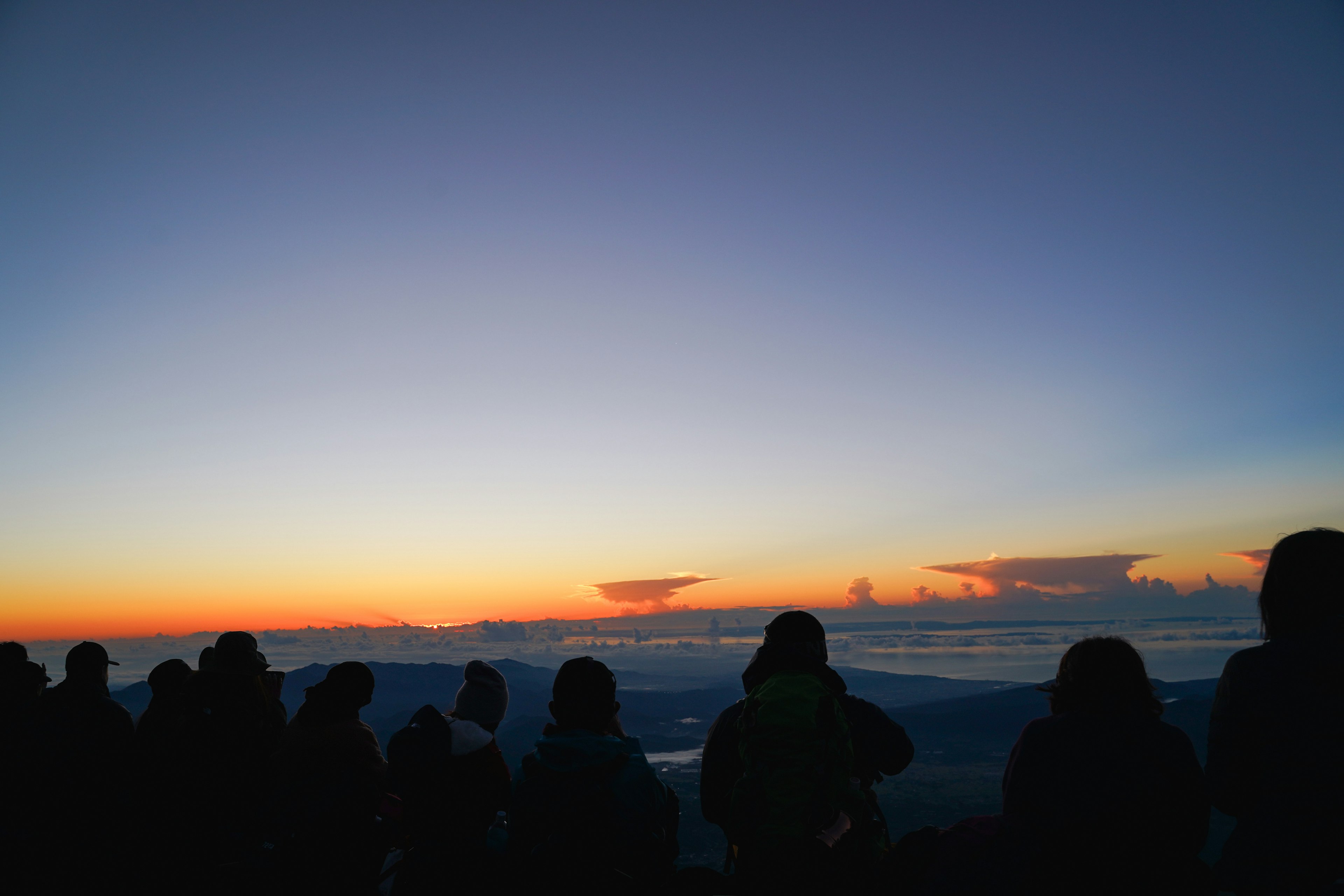 Silhouettes de personnes contre un coucher de soleil