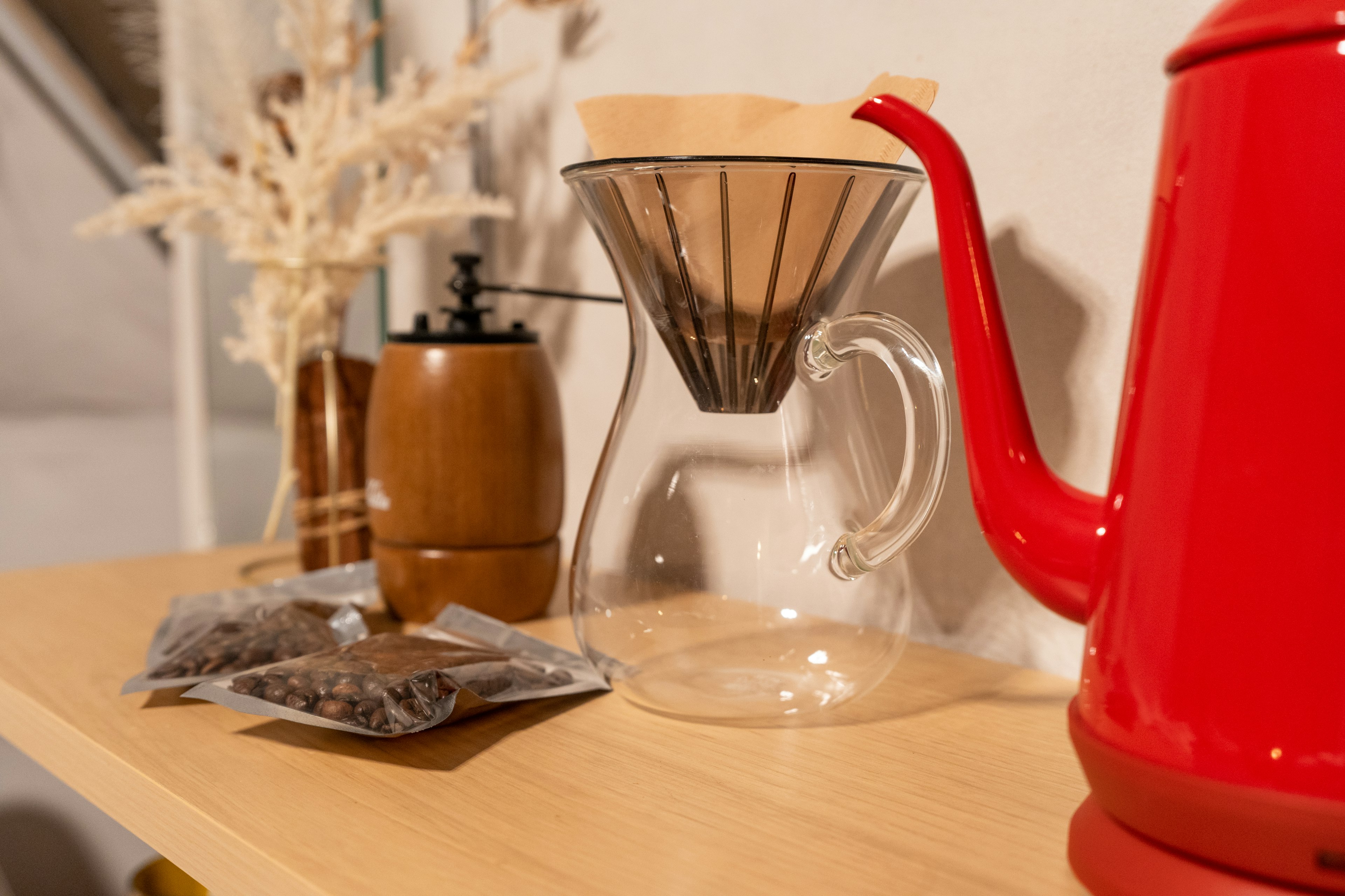 Cafe style scene featuring a red teapot and a clear coffee filter