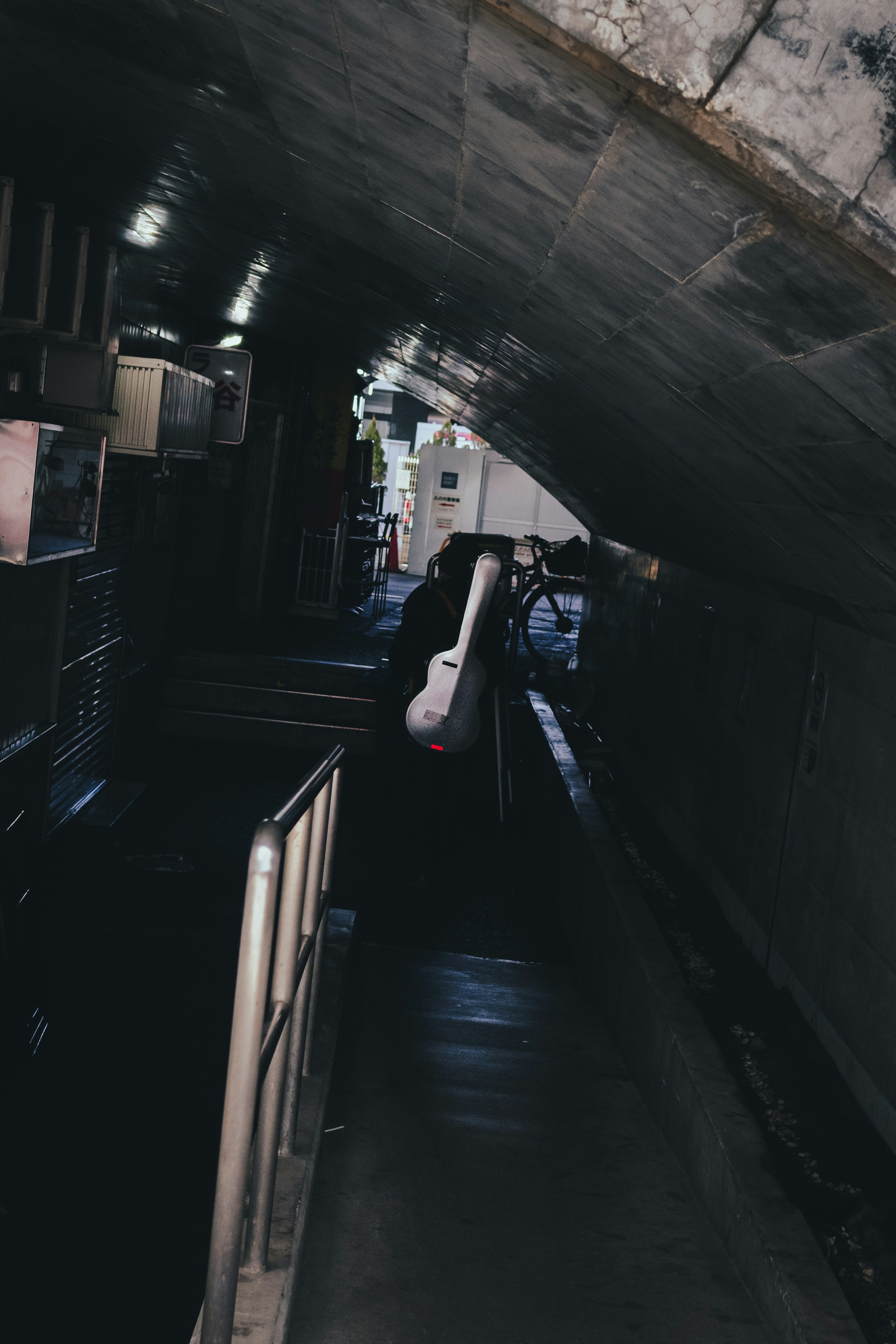 Passage souterrain sombre avec une silhouette de personne et des structures environnantes