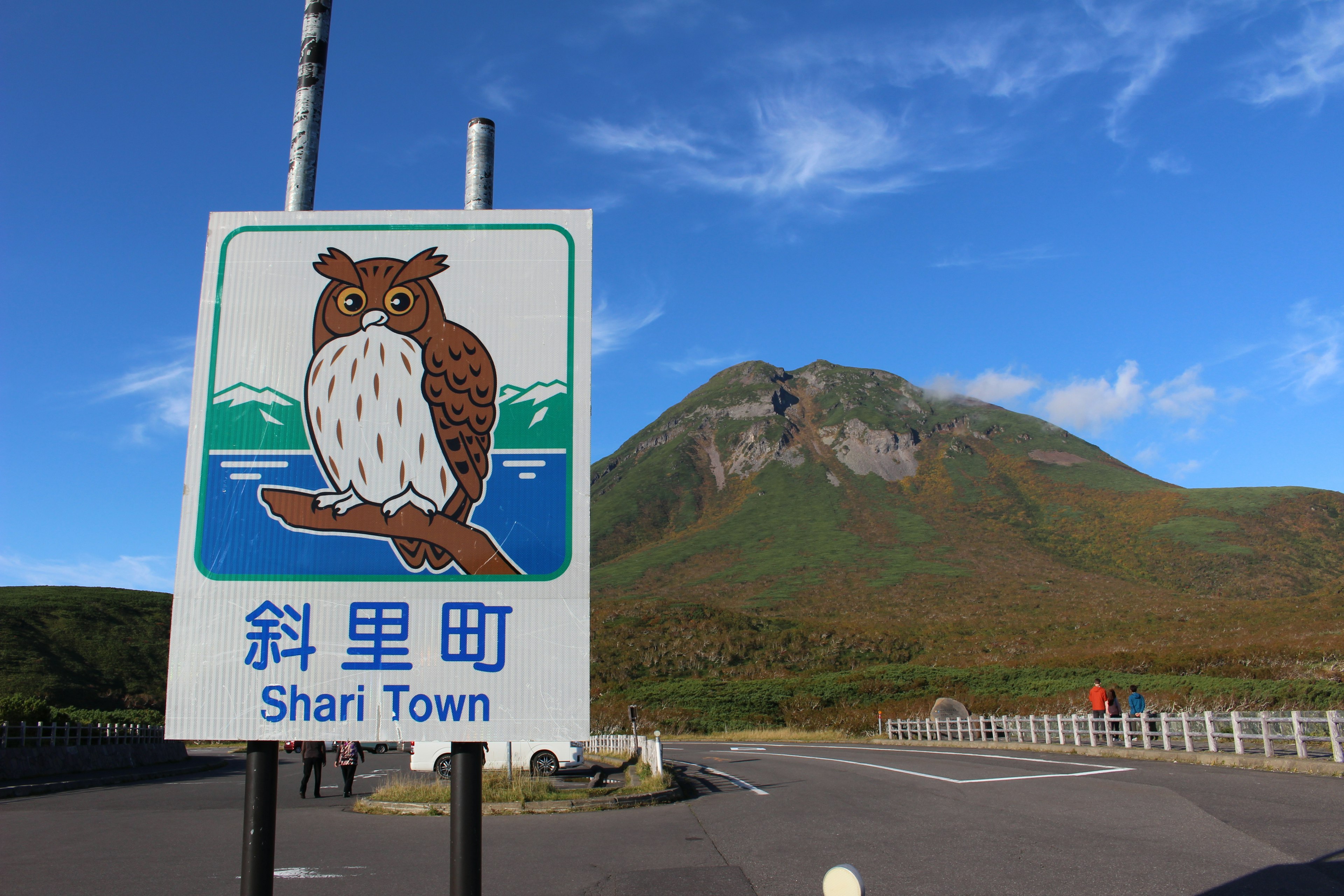 シャリ町の看板と山の風景