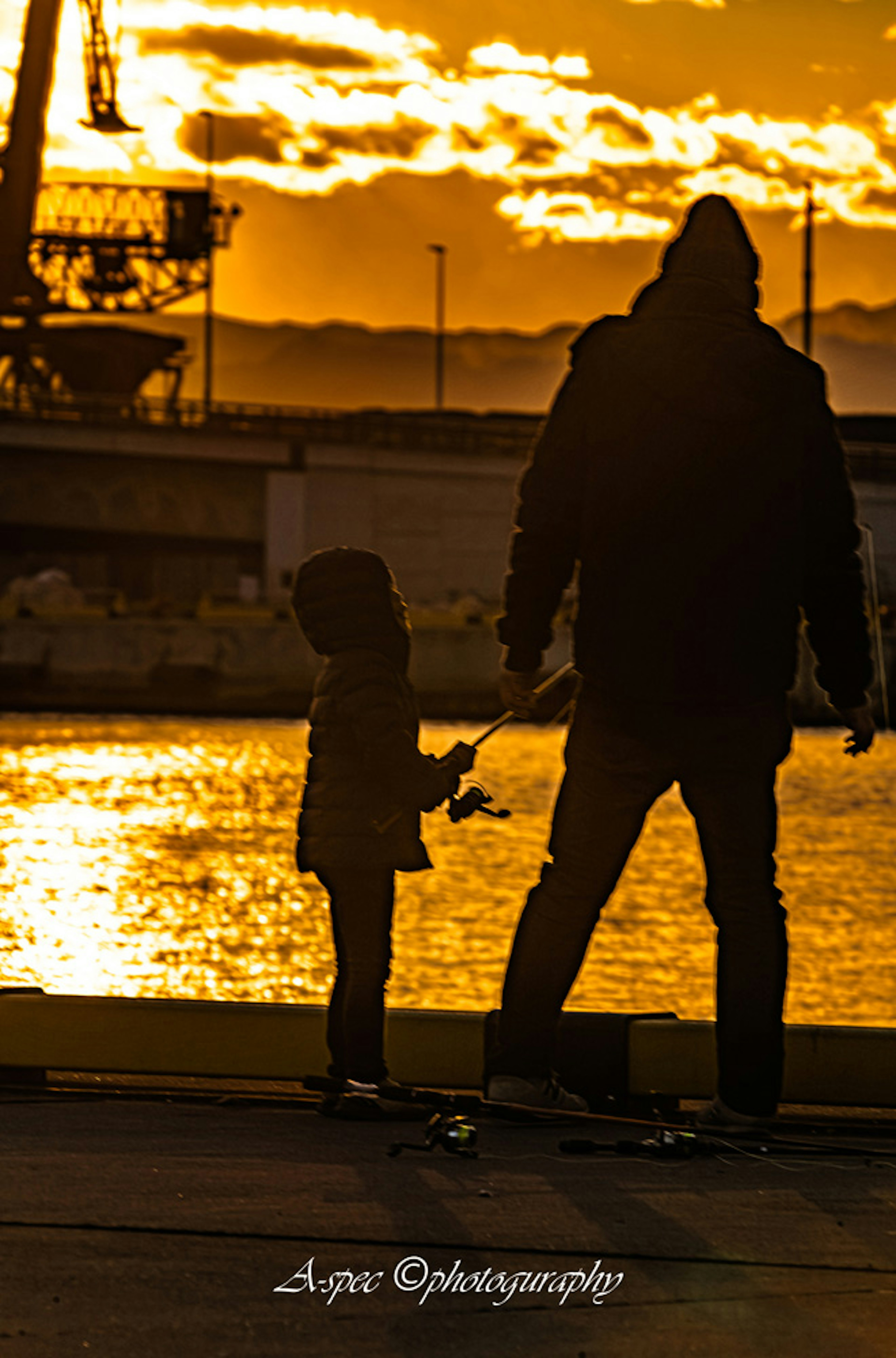 Silhouette eines Elternteils und eines Kindes vor einem Sonnenuntergang