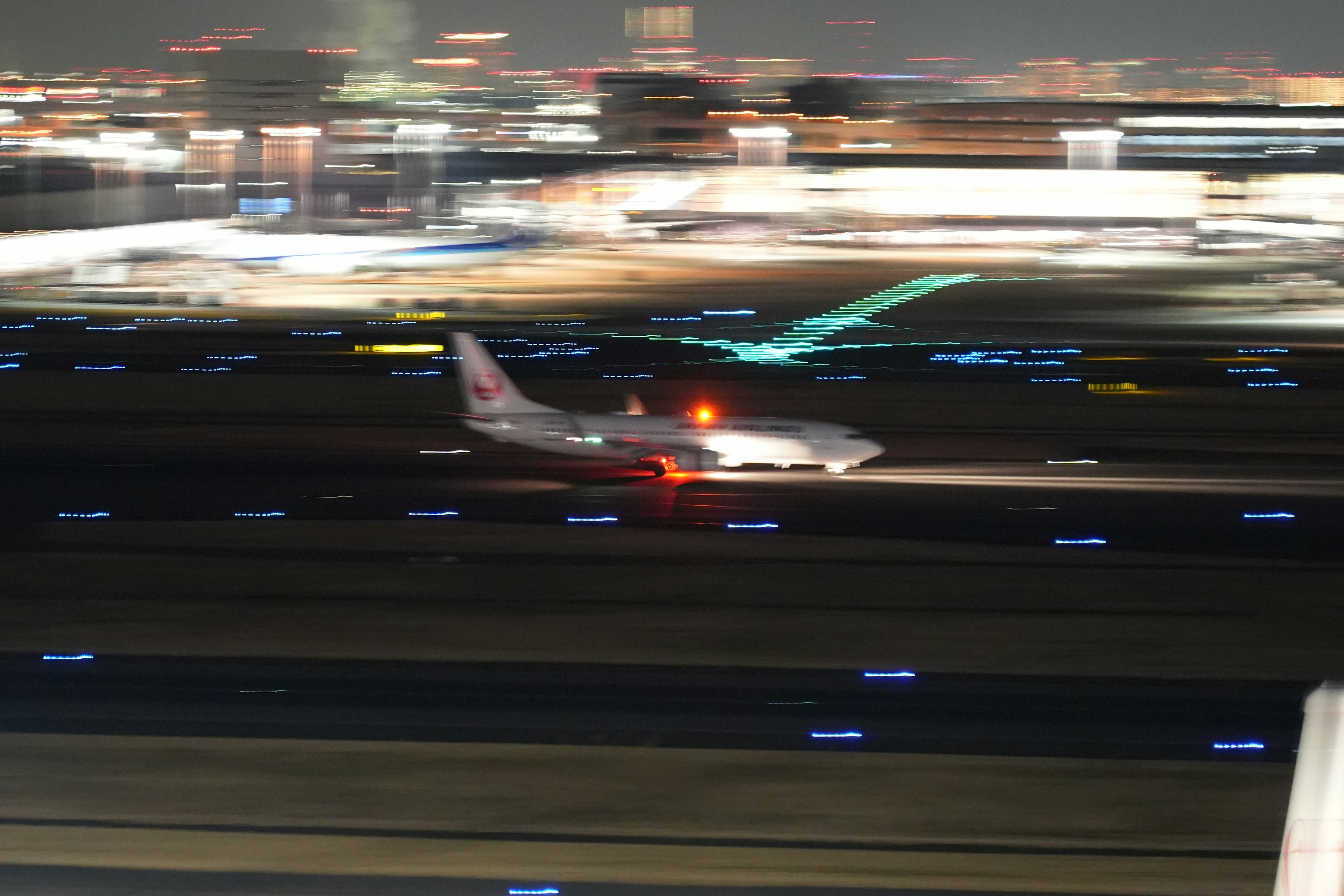 Imagen de un avión rodando por una pista de noche