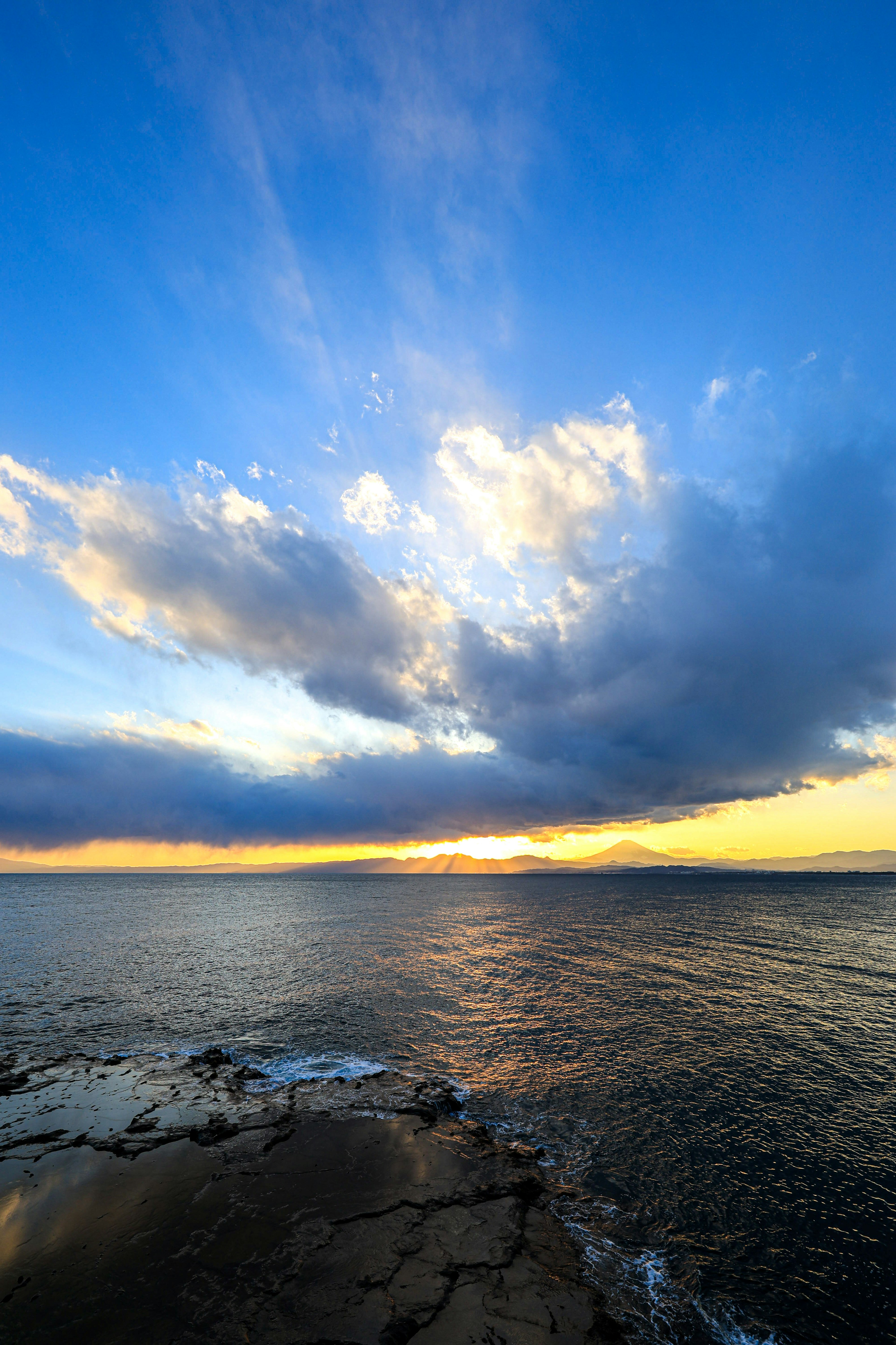 美しい海と青い空の景色に、雲が浮かび、夕日が沈む瞬間