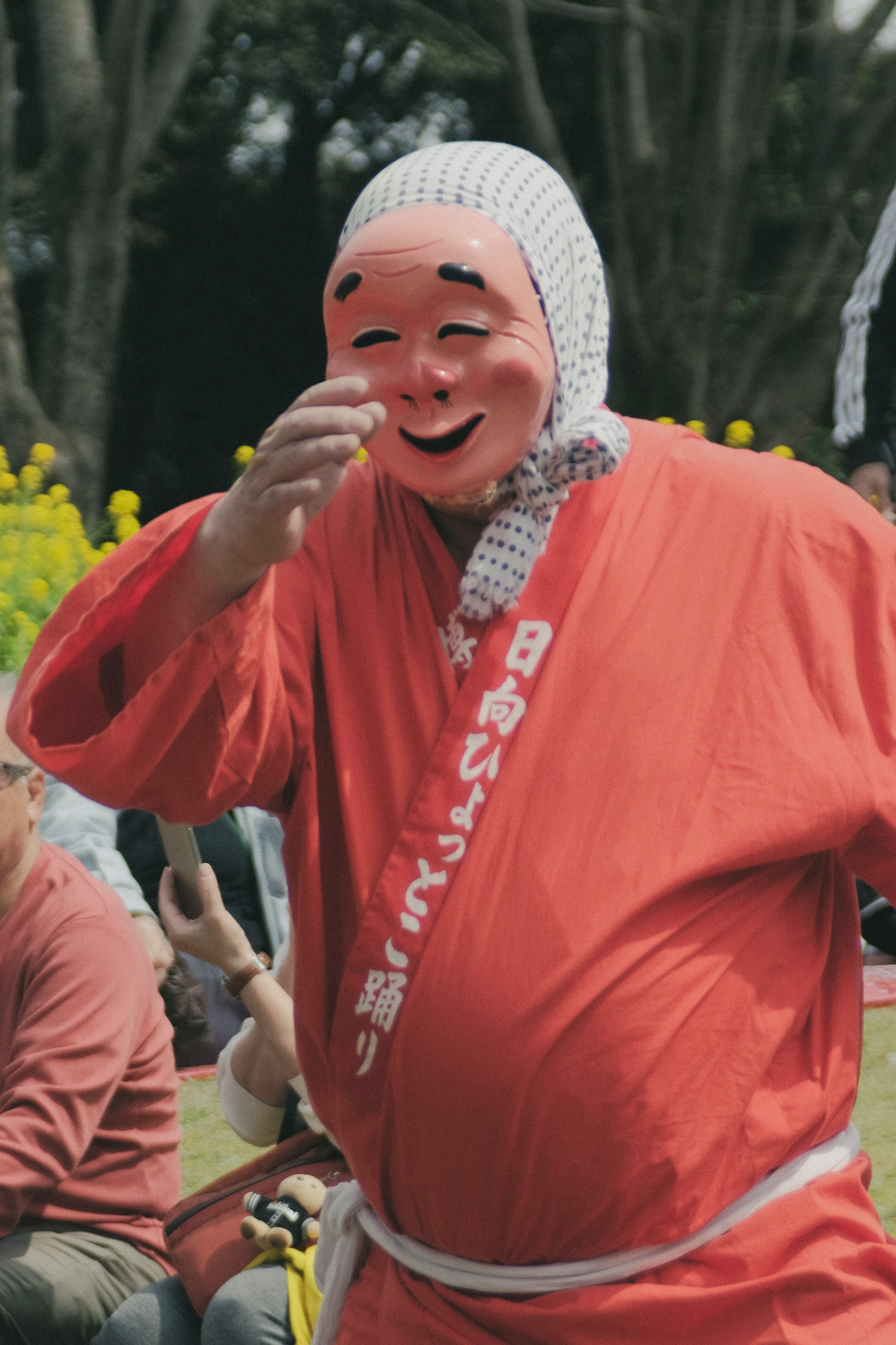 오렌지 의상을 입은 남성이 전통 일본 축제를 즐기고 있다